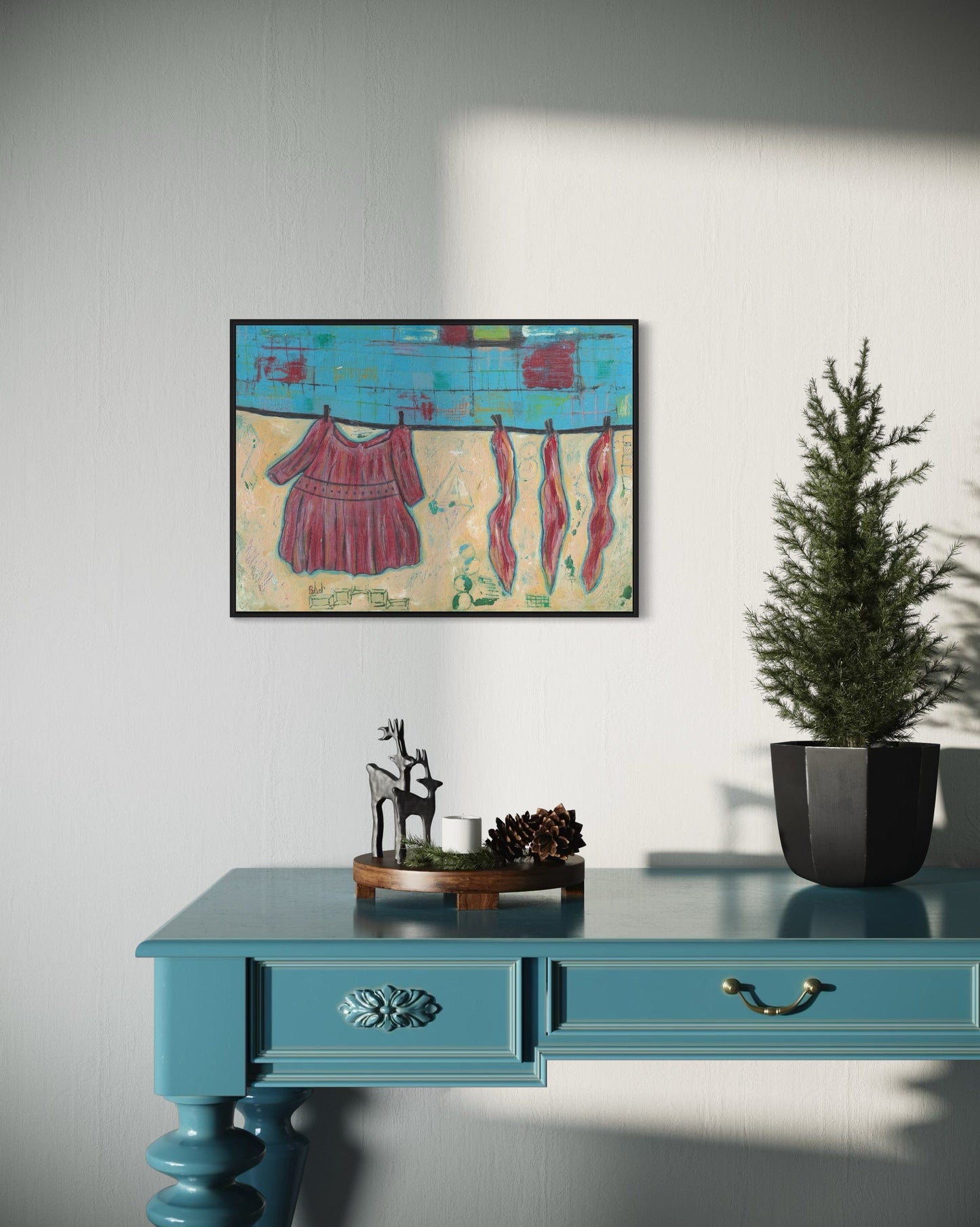 Colorful abstract painting on a wall above a blue desk with decorative items.