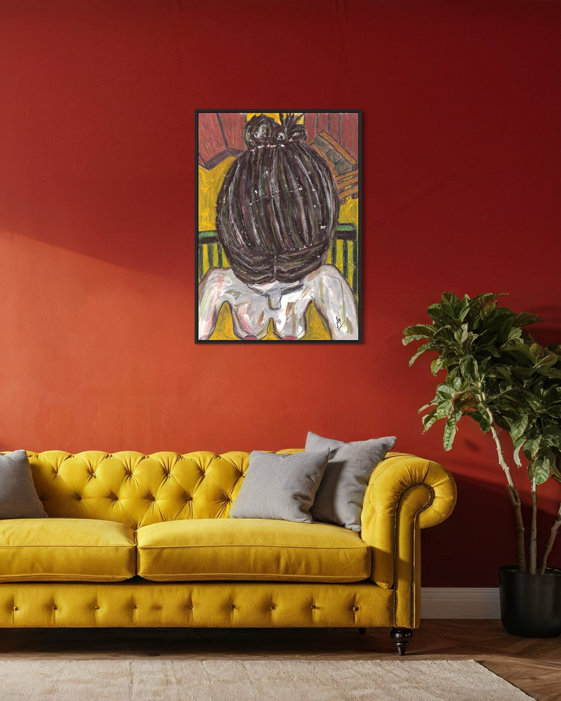 Yellow sofa with gray cushions in a room with a red wall and a framed artwork.