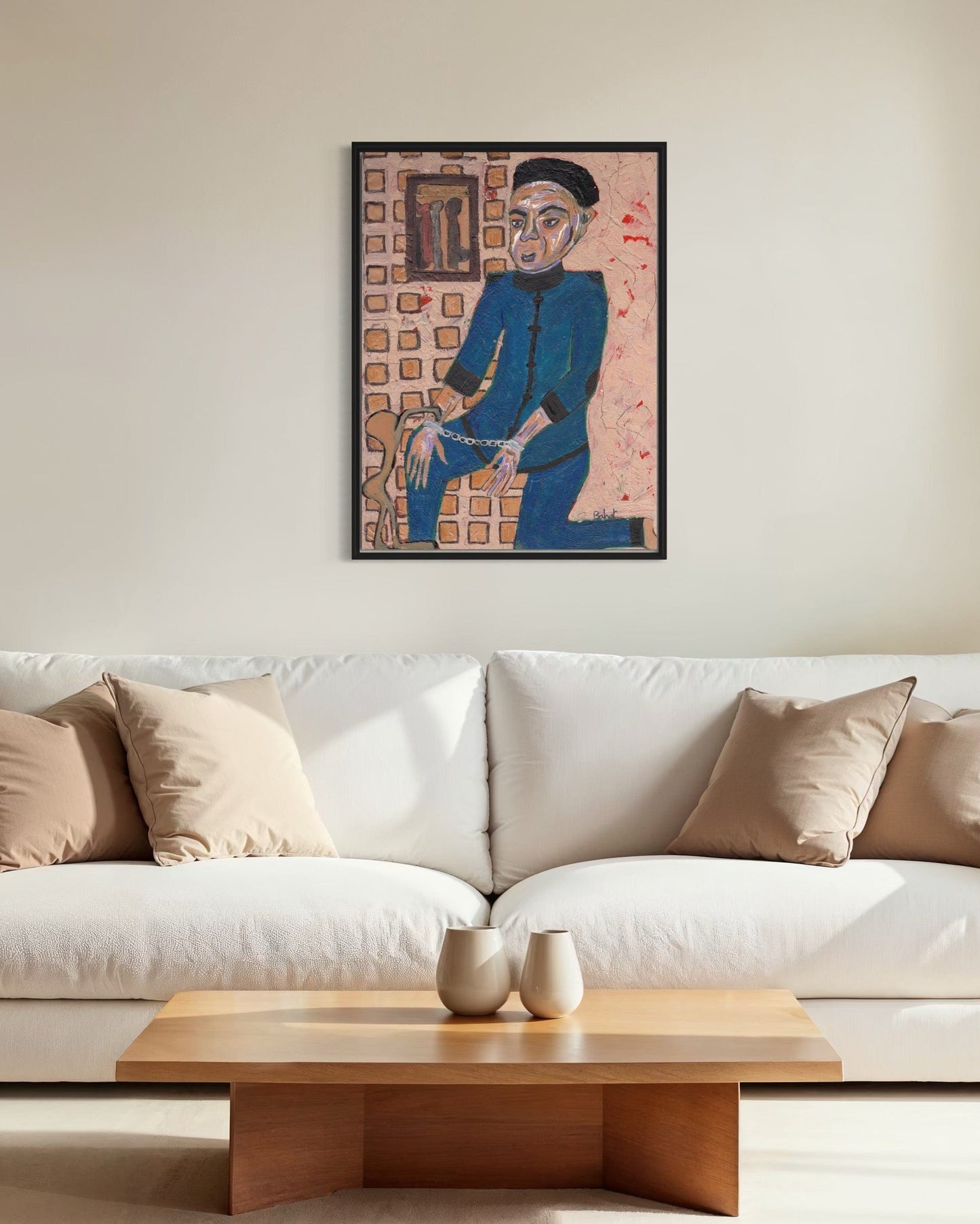 Framed artwork above a white sofa with a wooden coffee table in a living room.