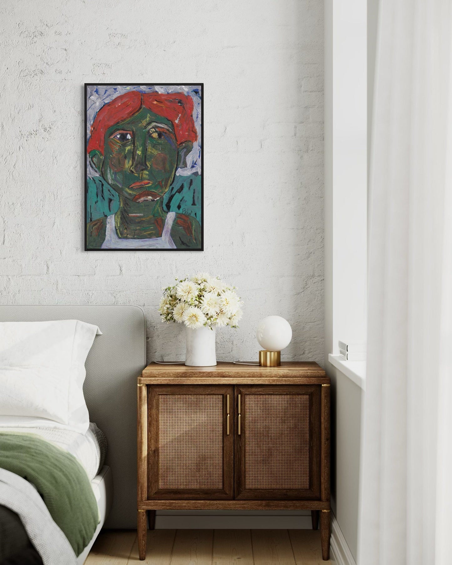 Artistic portrait on a wall above a wooden cabinet with decorative items in a bedroom.