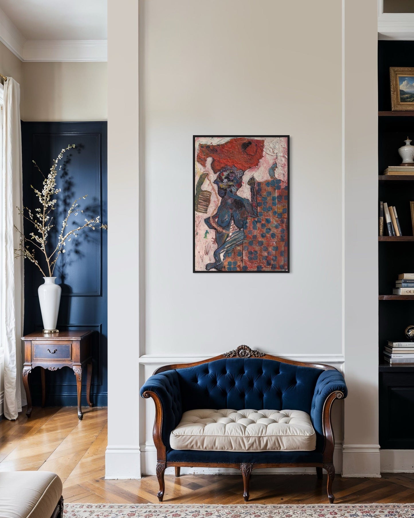Navy blue velvet sofa with beige cushion in a room with a colorful abstract painting on the wall.