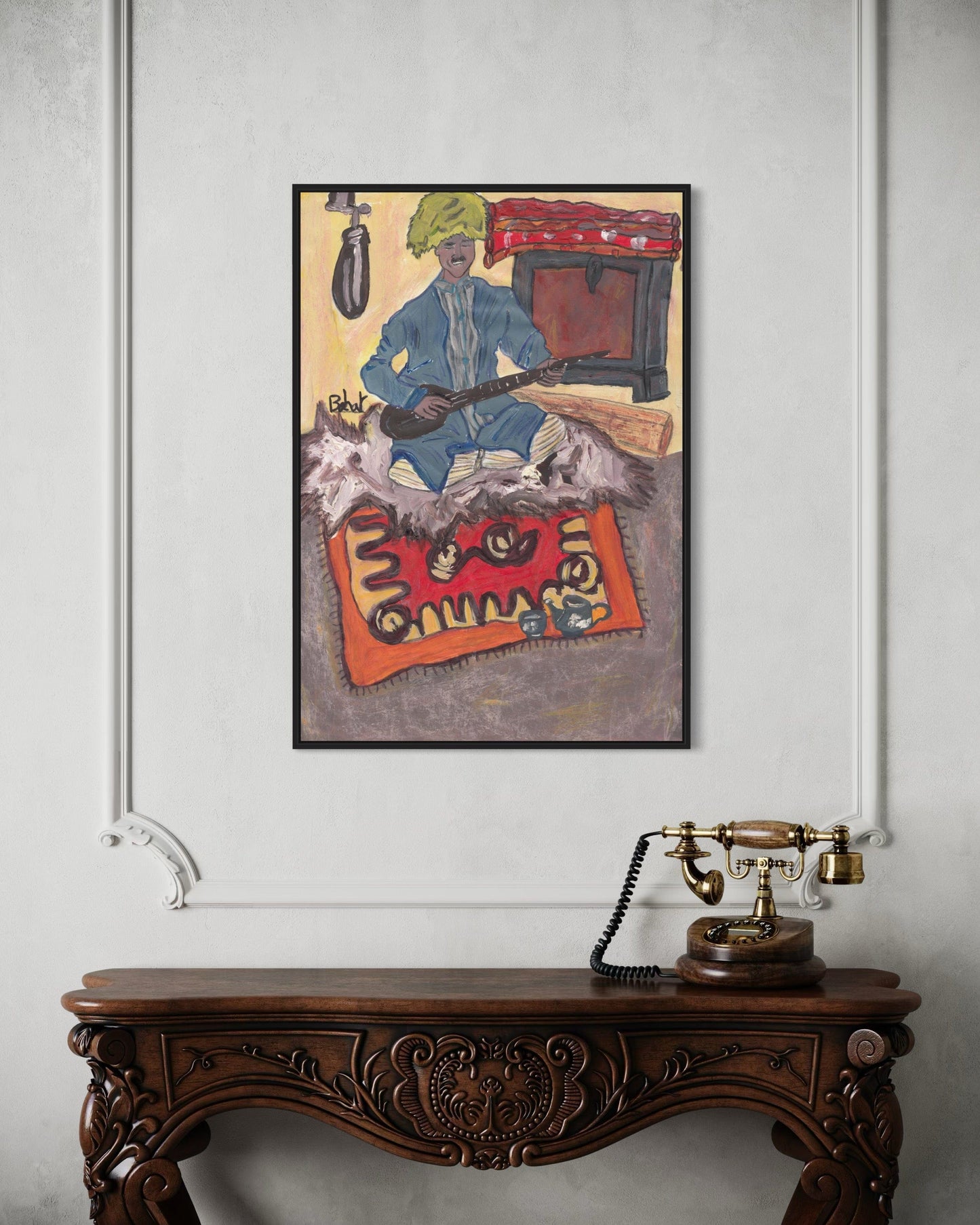 Framed artwork on a wall above an ornate wooden console table with a vintage telephone.