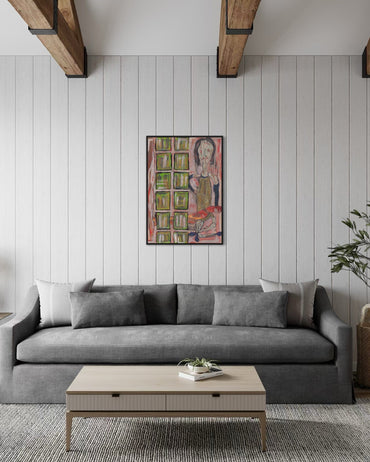Gray sofa in a living room with a colorful painting on the wall.