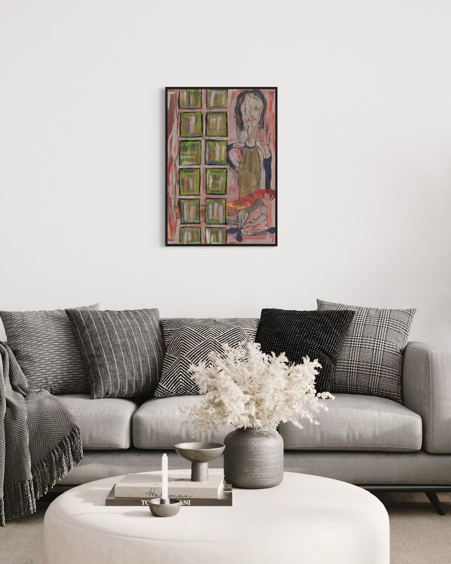 Living room with a gray sofa, decorative pillows, a vase with flowers, and a colorful abstract painting on the wall.