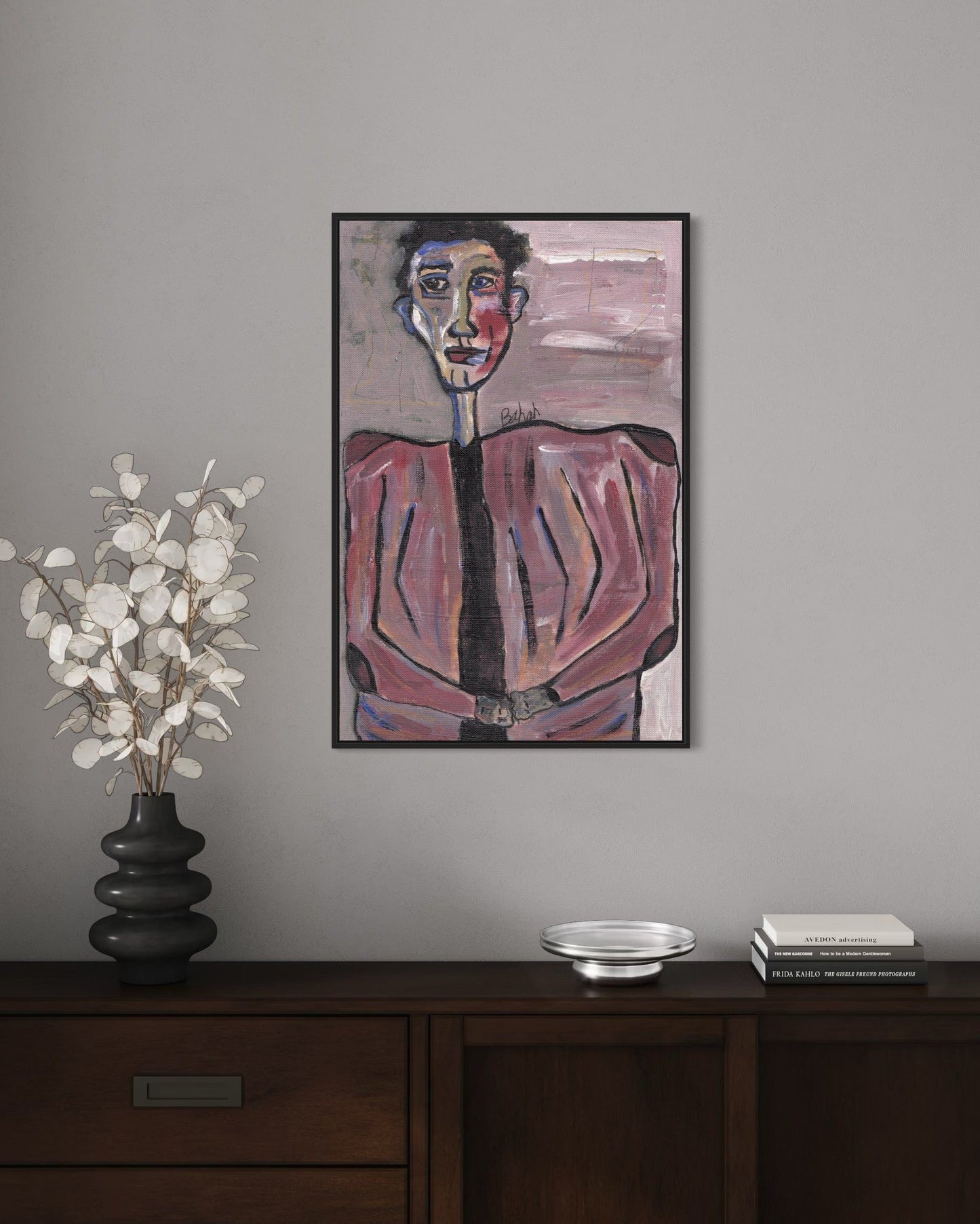 Framed abstract painting on a wall above a wooden console table with decorative items.
