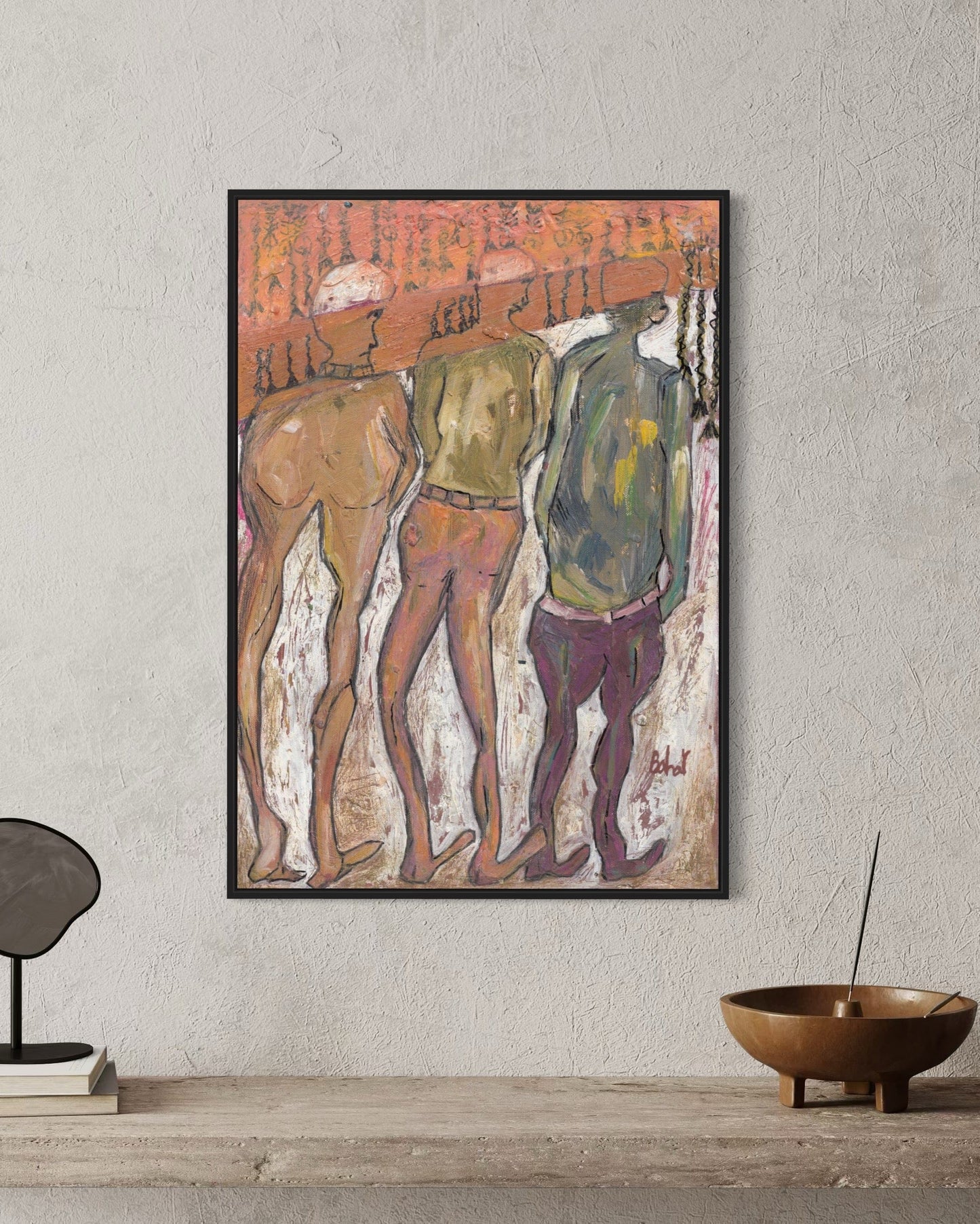 Framed artwork of three figures on a textured wall with minimal decor.