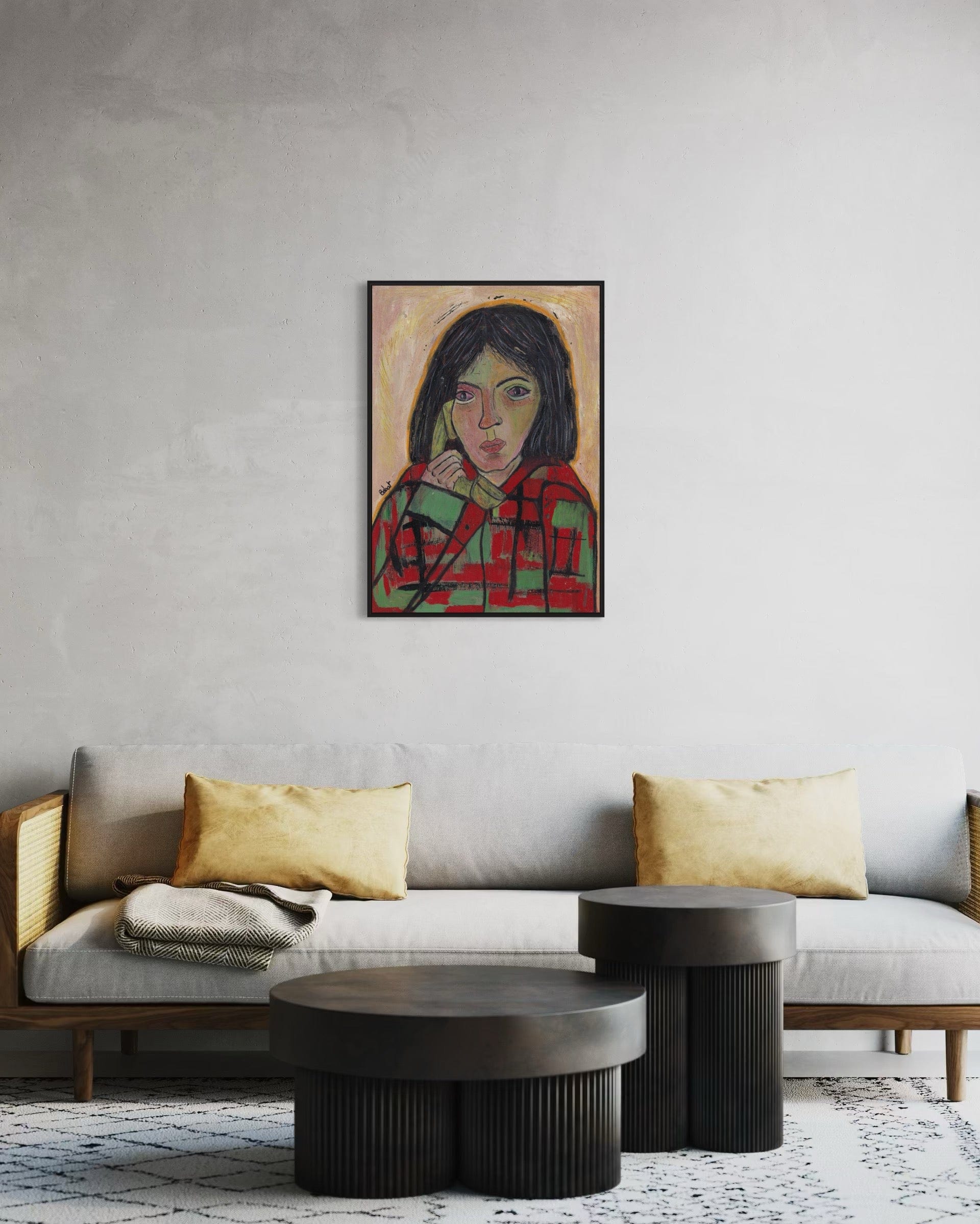 Living room with a gray sofa, gold pillows, and a framed portrait on the wall.