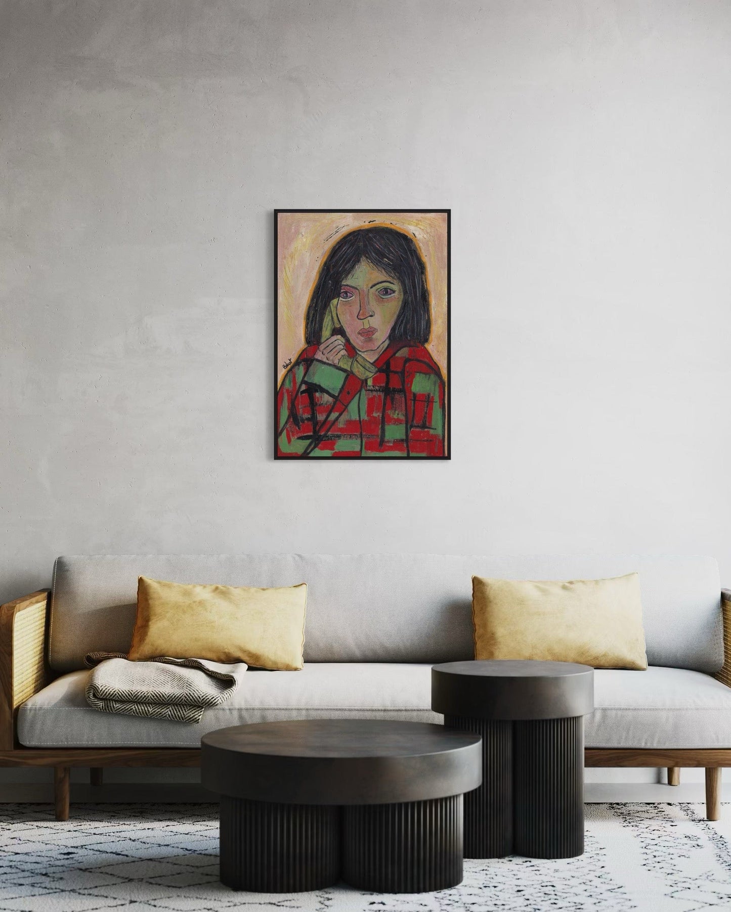 Living room with a gray sofa, gold pillows, and a framed portrait on the wall.