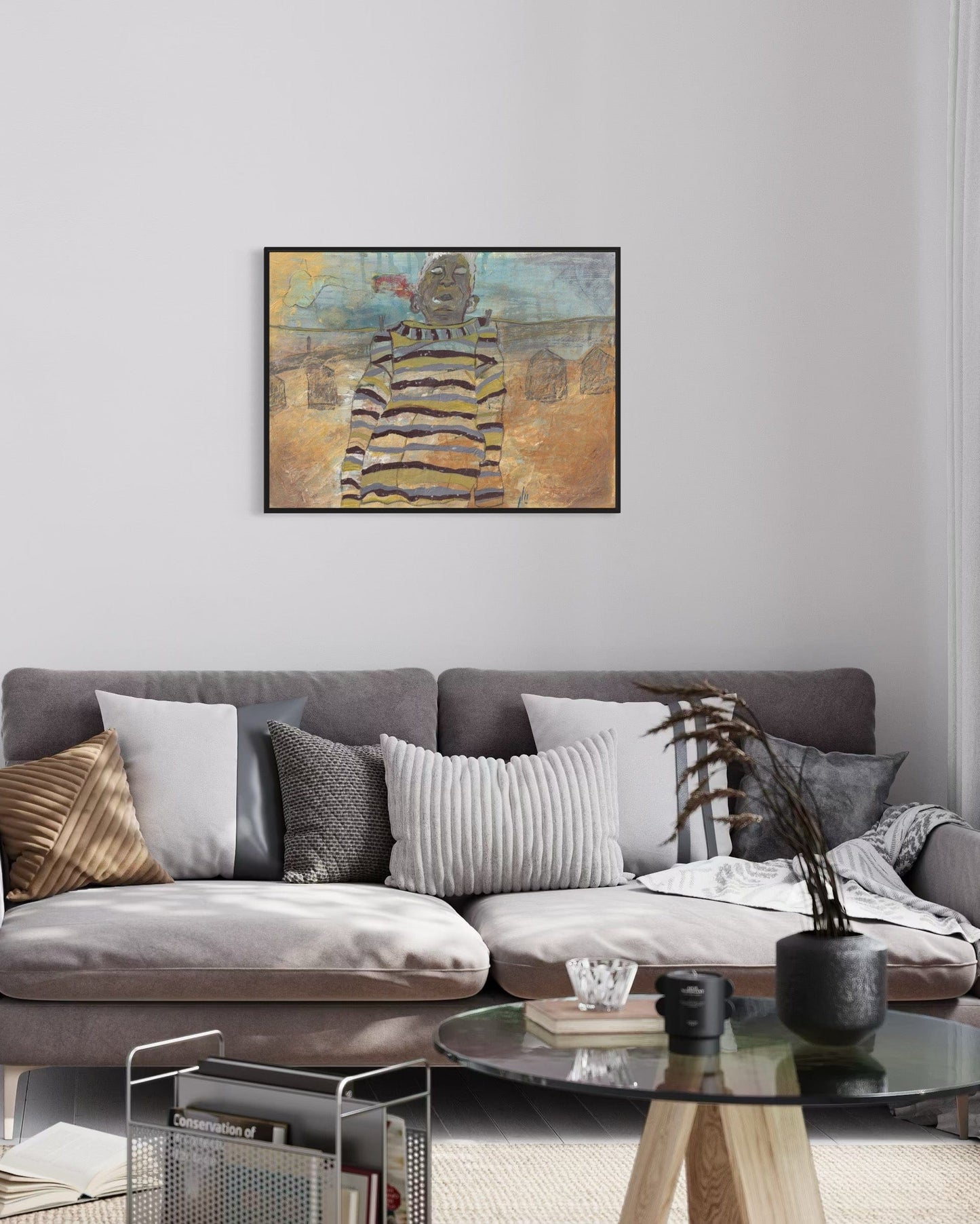 Living room with a gray sofa, decorative pillows, and a framed abstract painting on the wall.
