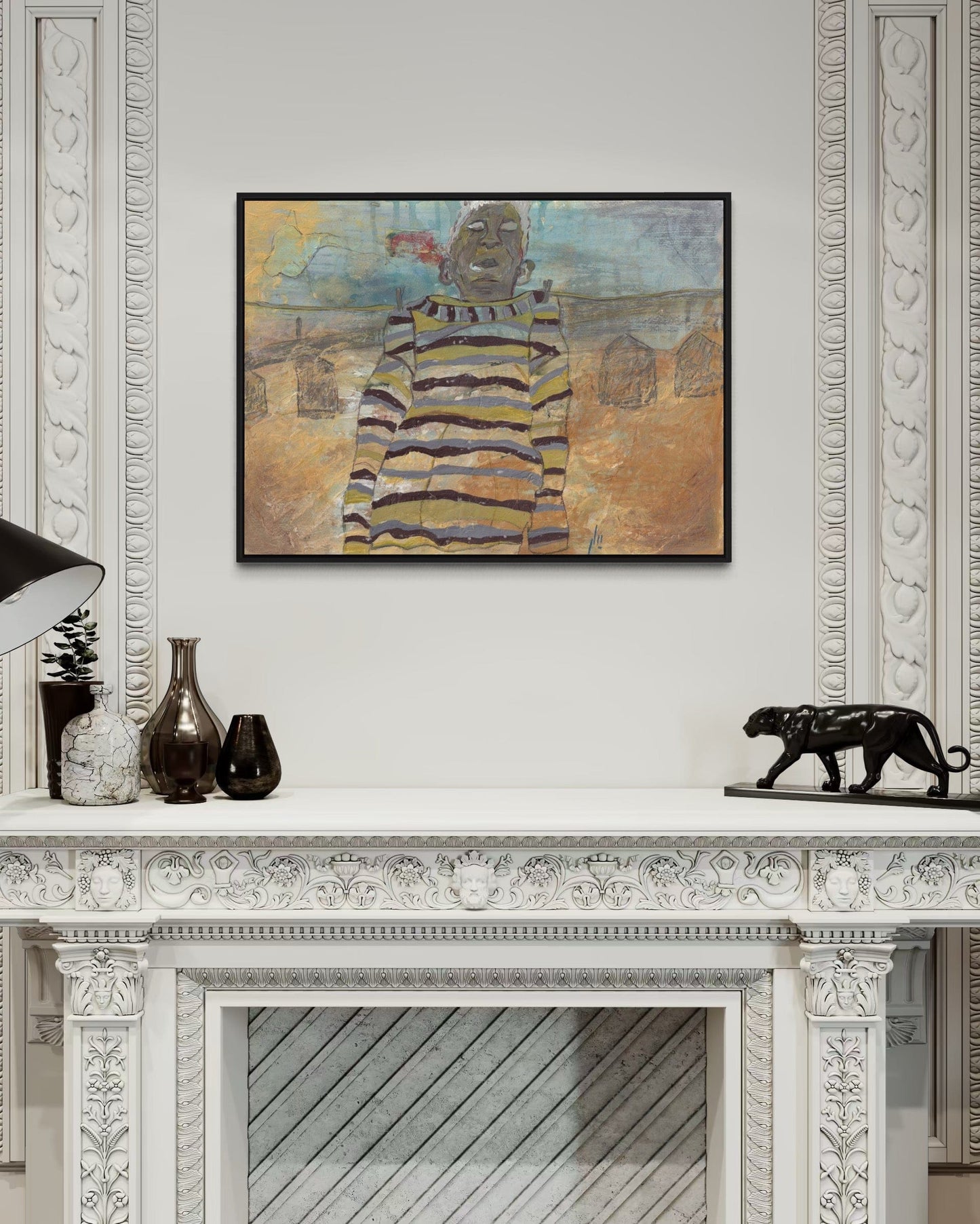 Framed artwork on a wall above a decorative fireplace mantle.