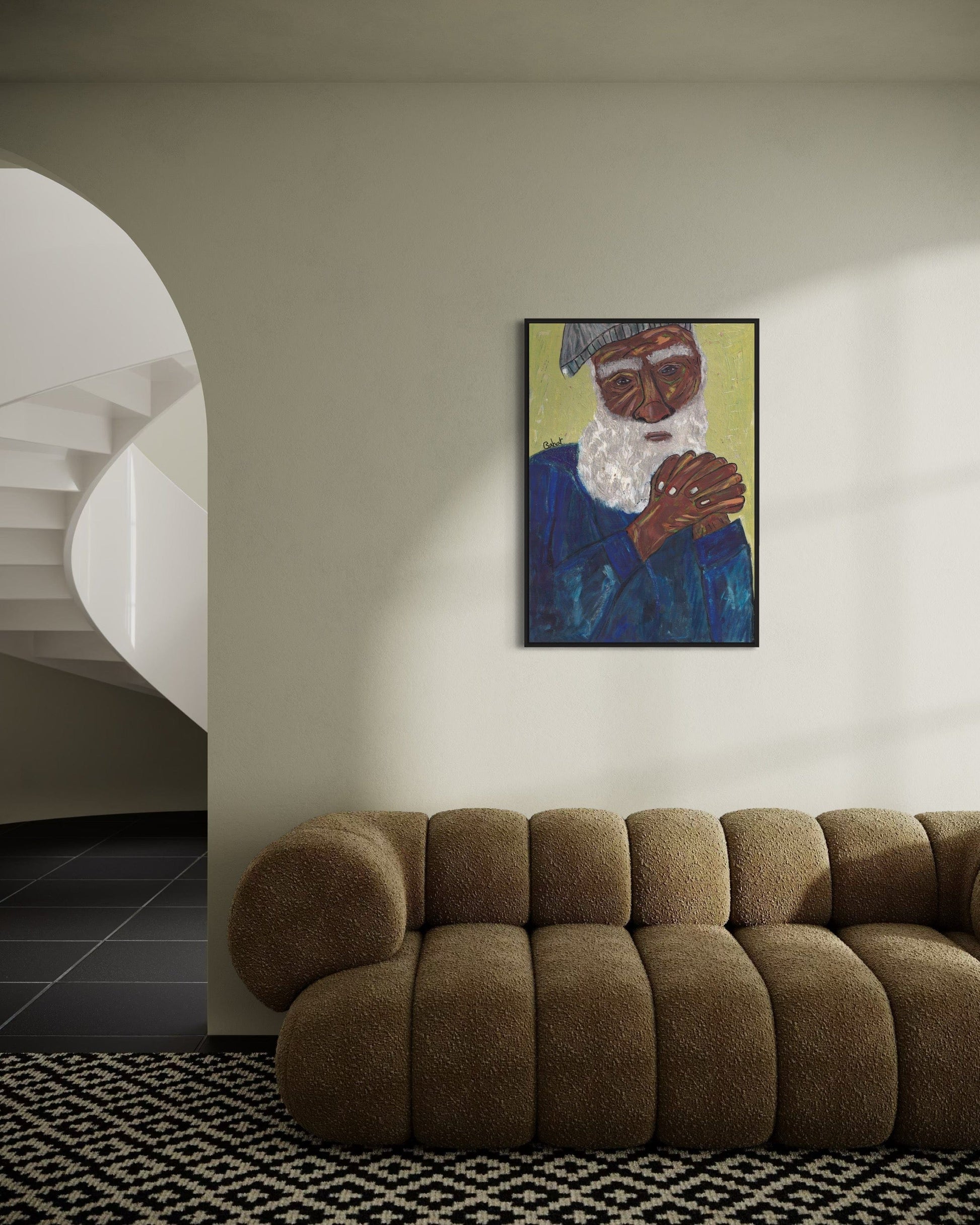 Brown sofa in a room with a wall painting of an elderly man.