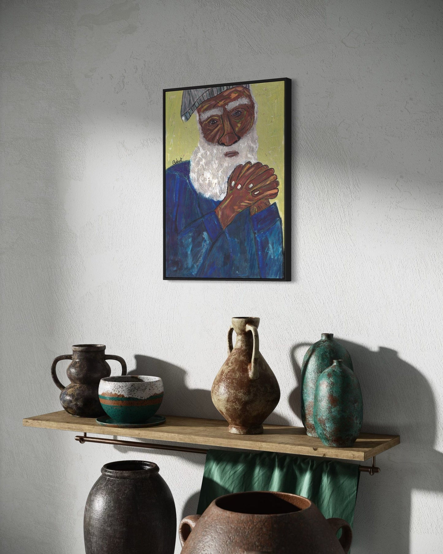 Framed artwork of a person with a white beard and blue robe above a wooden shelf with various ceramic pots.