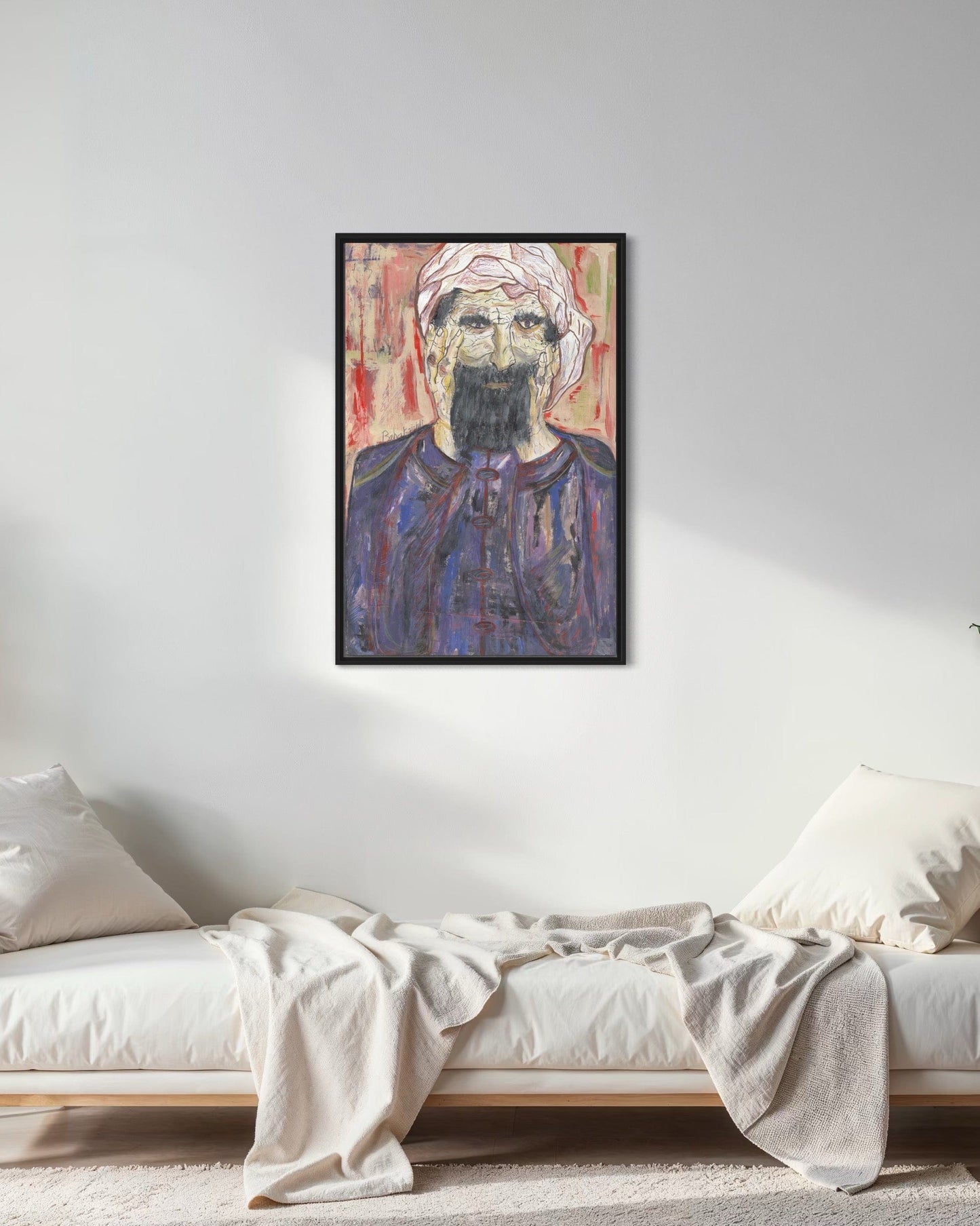 Framed painting of a man with a turban on a wall above a bed.