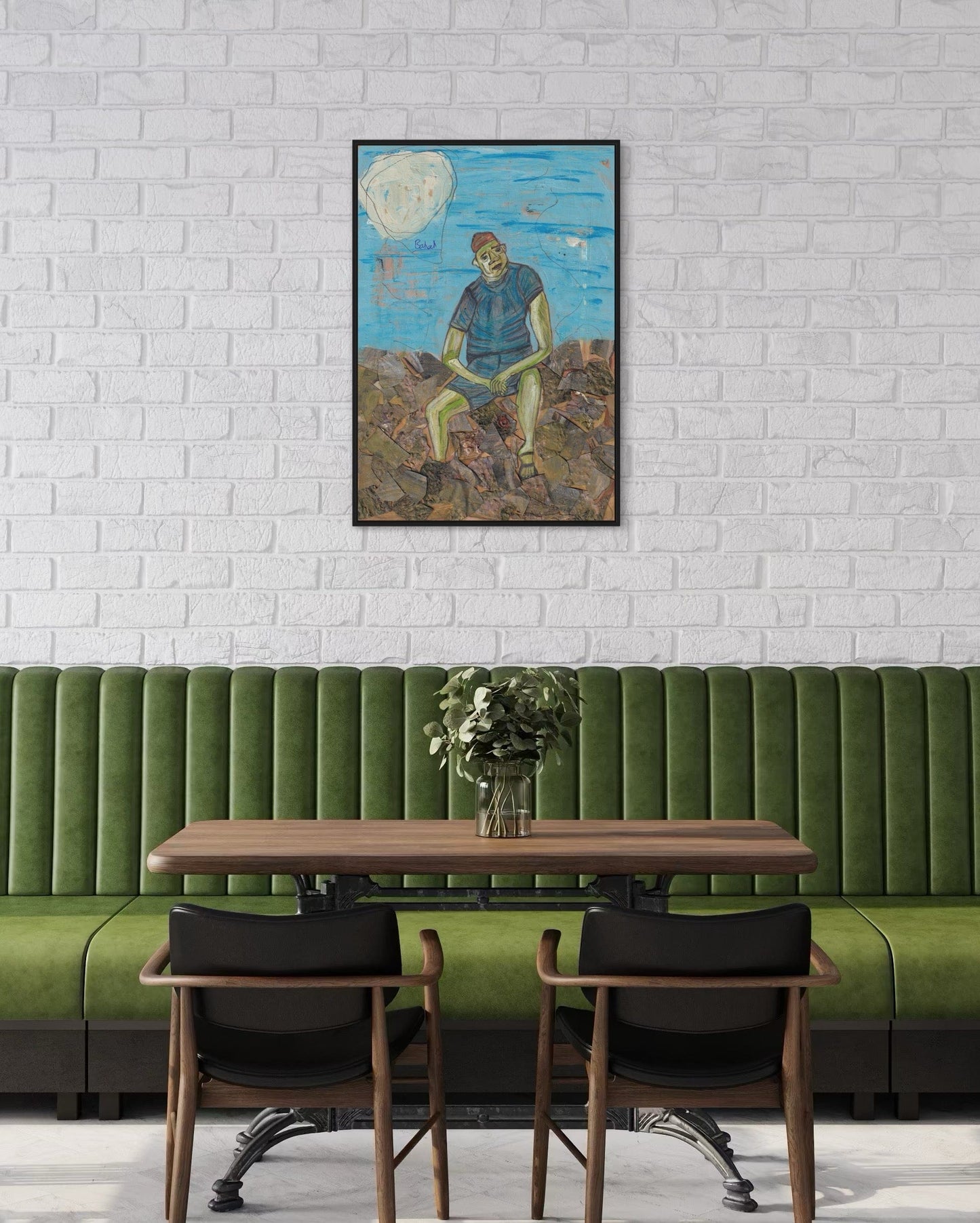 Green booth with wooden table and chairs against a white brick wall with a framed painting.
