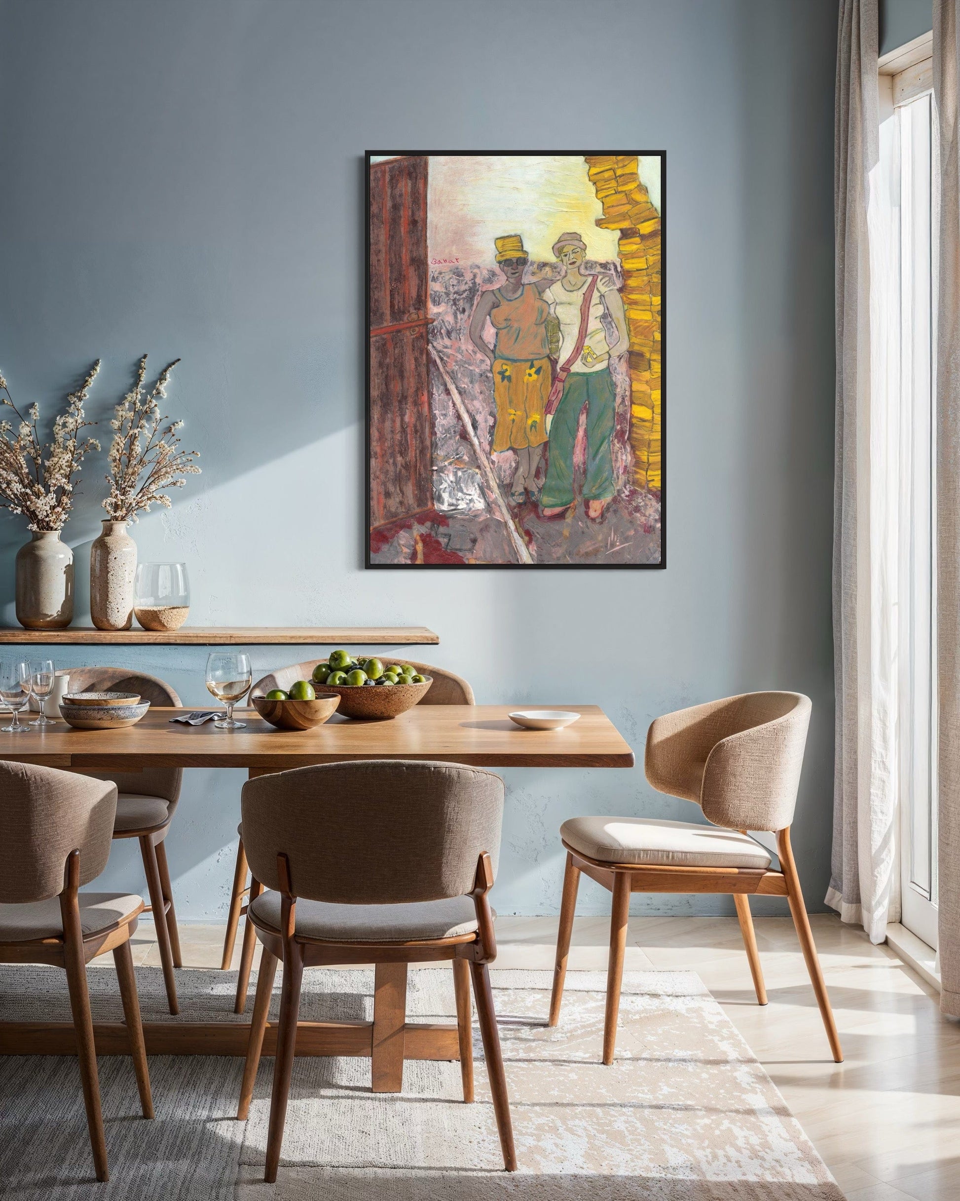 Dining room with wooden table and chairs, framed artwork on the wall, and natural light.