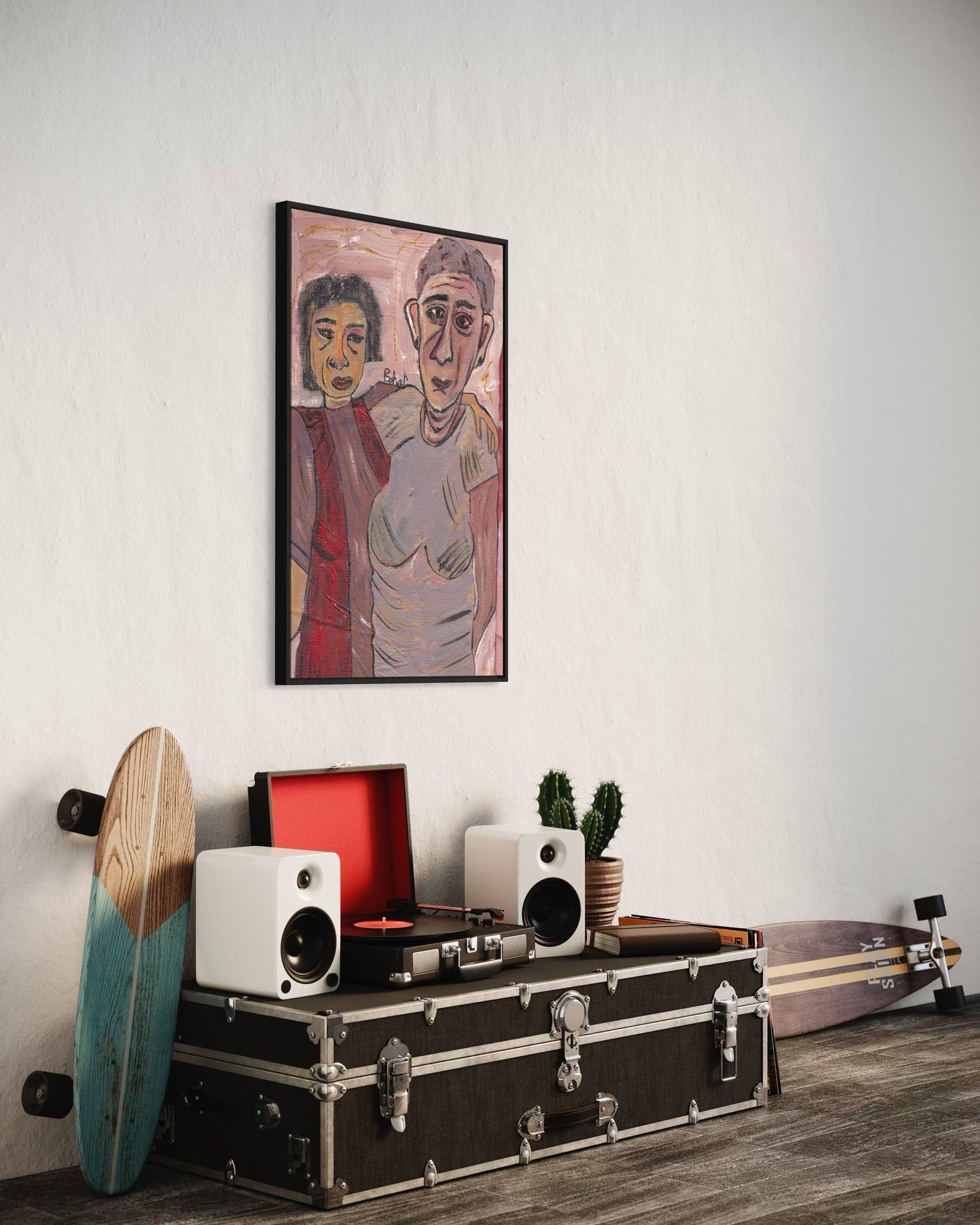 Room interior with a framed artwork, speakers, and a skateboard on a wooden floor.