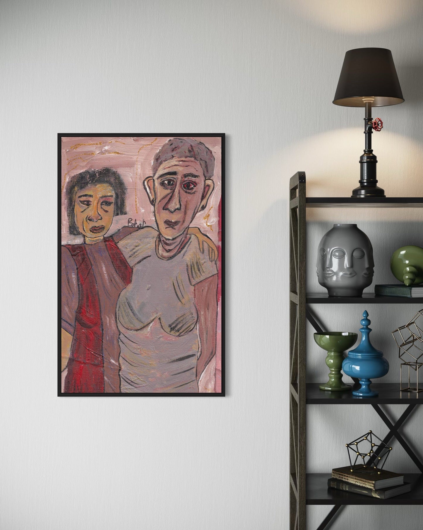 Framed artwork of two people on a wall next to a shelf with decorative items.