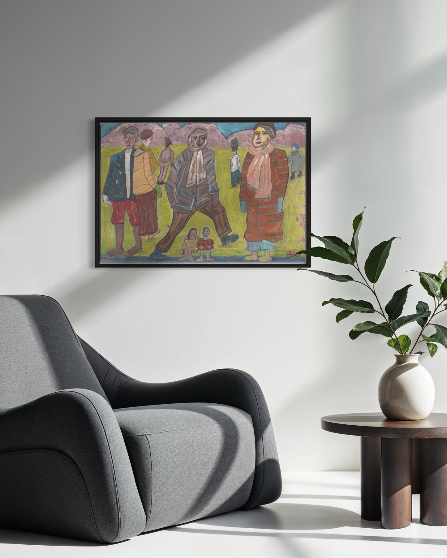Framed artwork on a wall above a gray armchair with a plant on a side table.