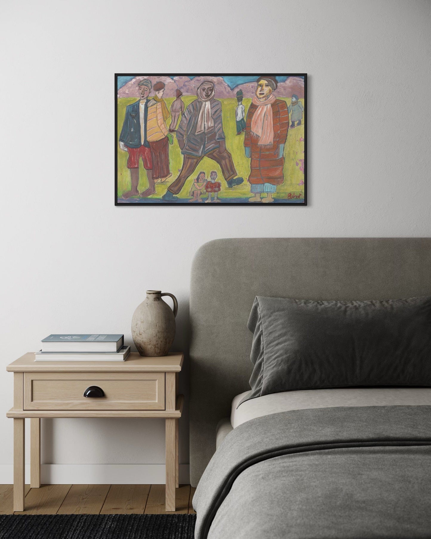 Bedroom with a bed, side table, and framed artwork on the wall.