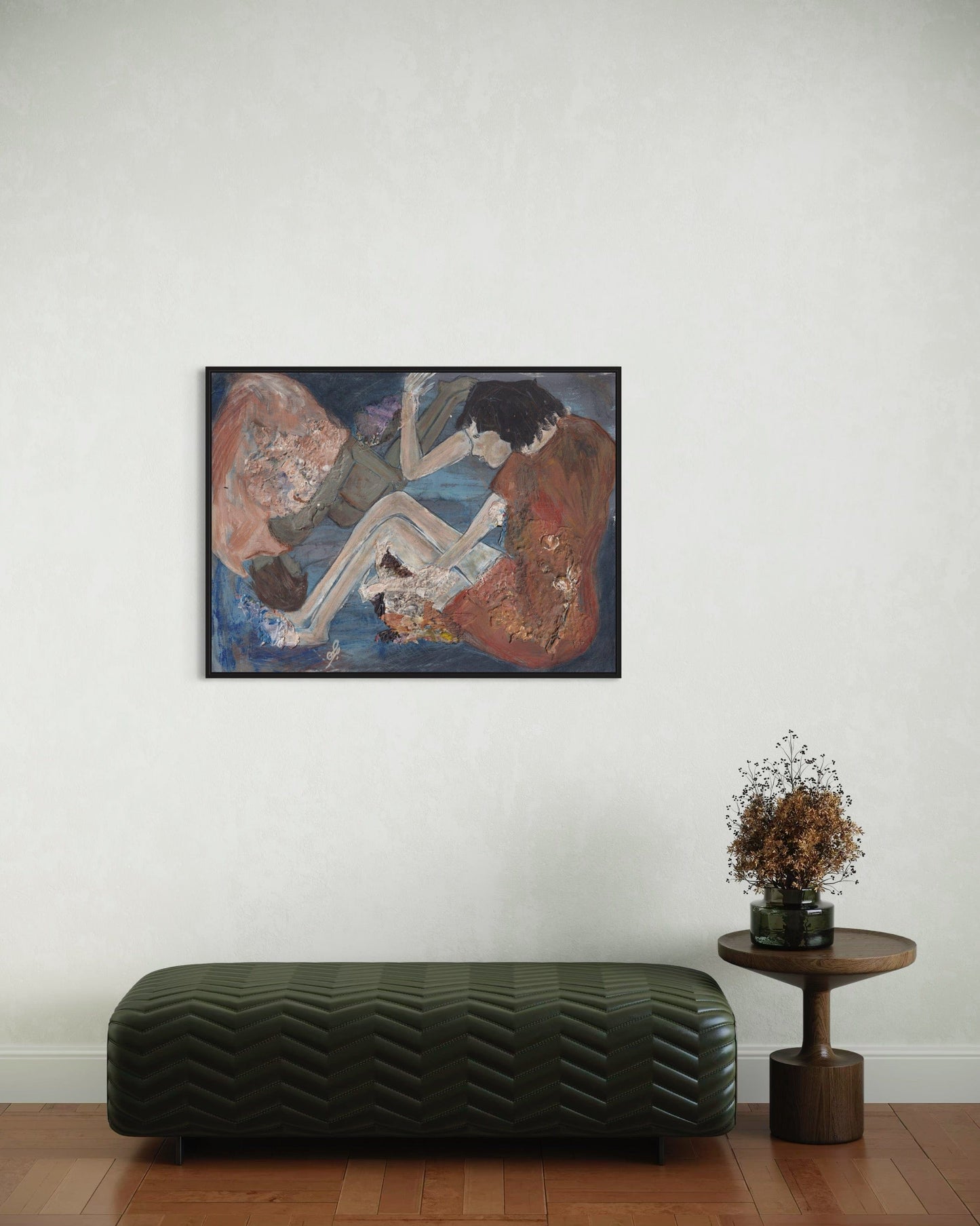 Framed artwork on a wall above a bench and small table with a plant.