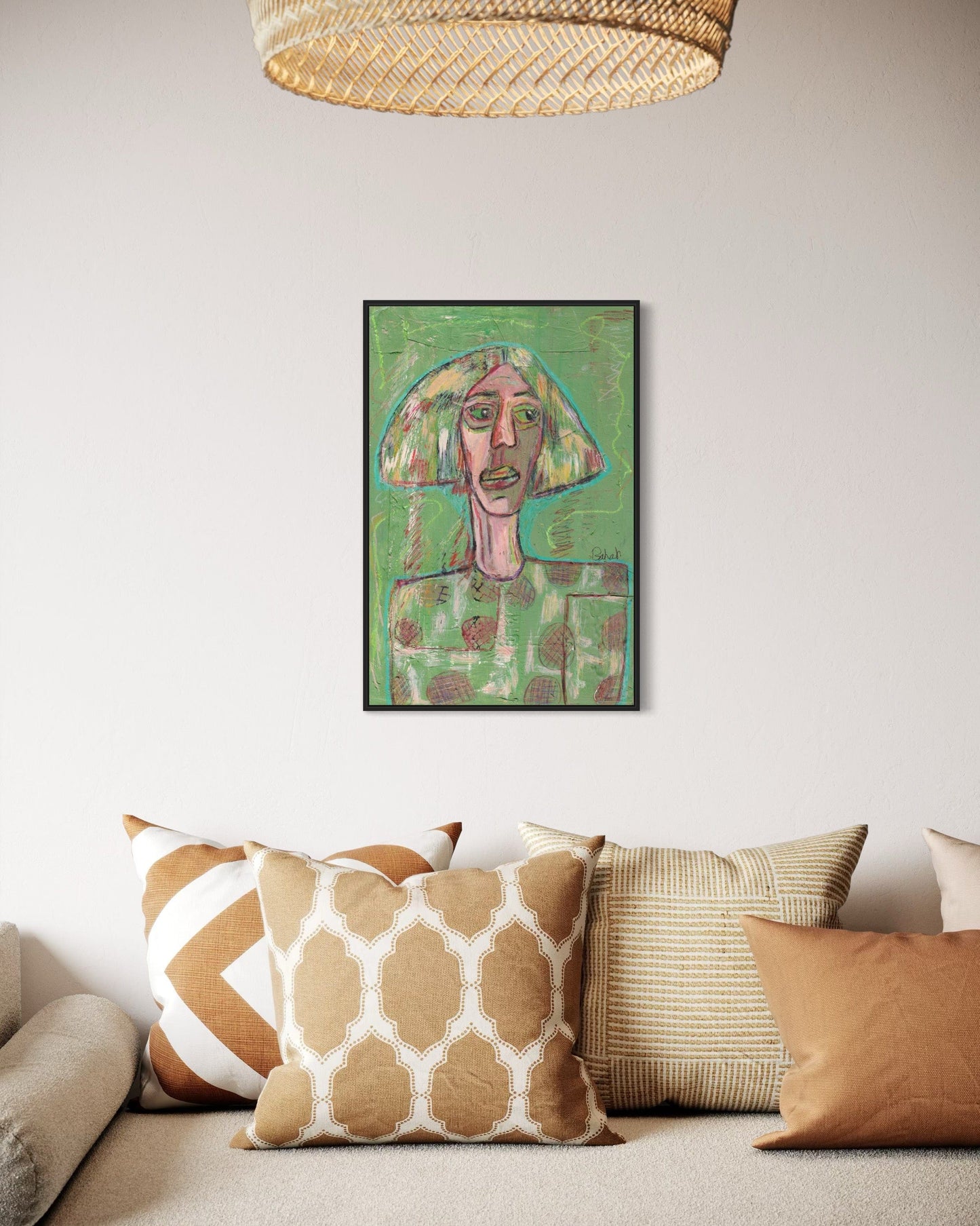Framed artwork on a wall above a sofa with patterned cushions.