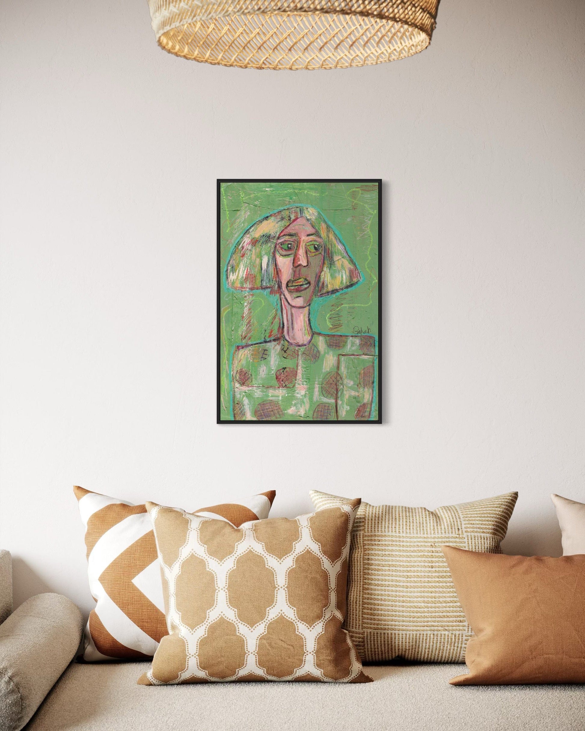 Framed artwork on a wall above a sofa with patterned cushions.