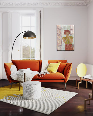 Modern living room with orange sofa, yellow rug, and decorative elements.