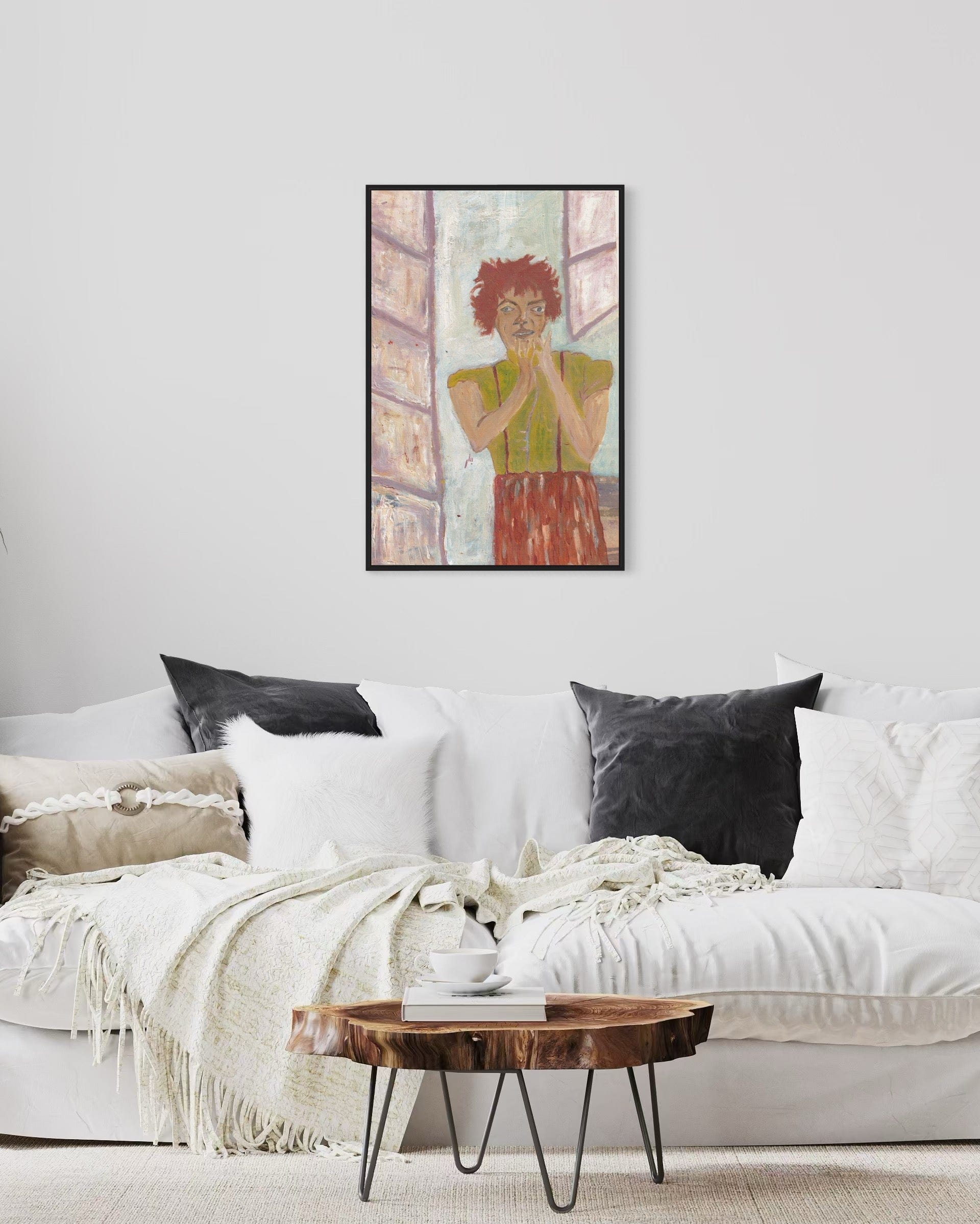 Framed artwork above a white sofa with black cushions in a living room setting.