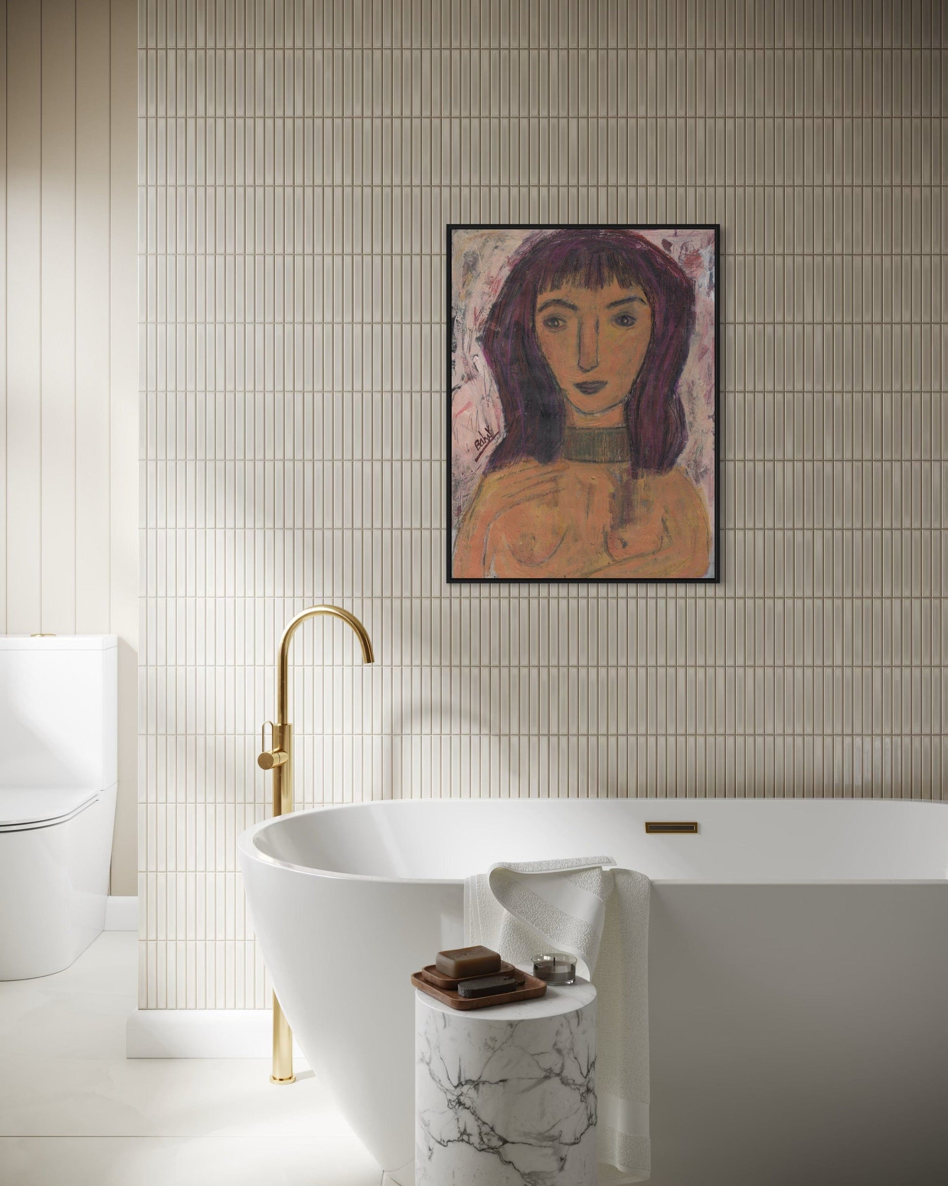 Bathroom with a freestanding bathtub, gold faucet, and framed artwork on the wall.
