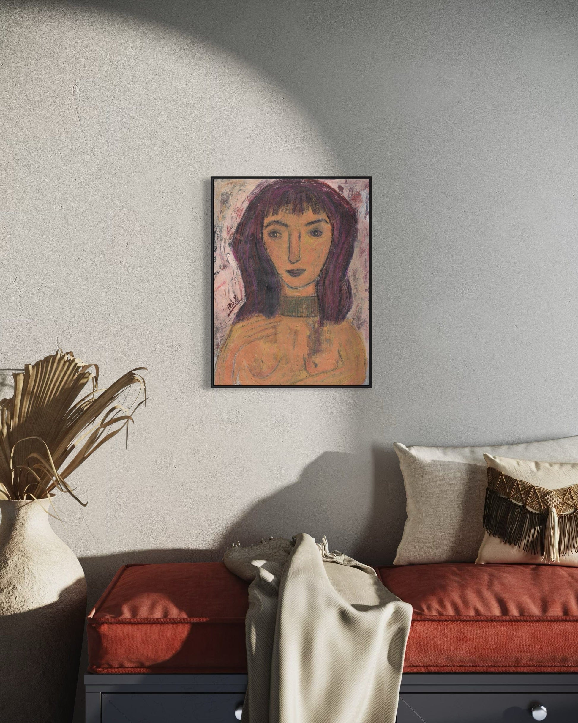Framed artwork on a wall above a sofa with decorative pillows