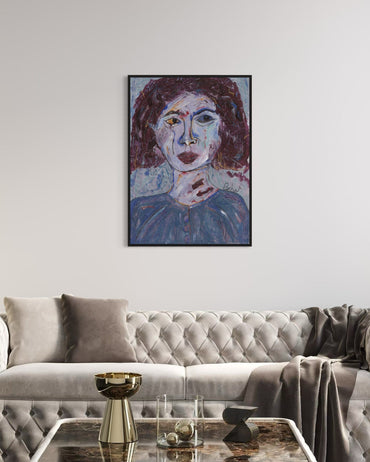 Framed abstract portrait above a gray sofa in a living room.