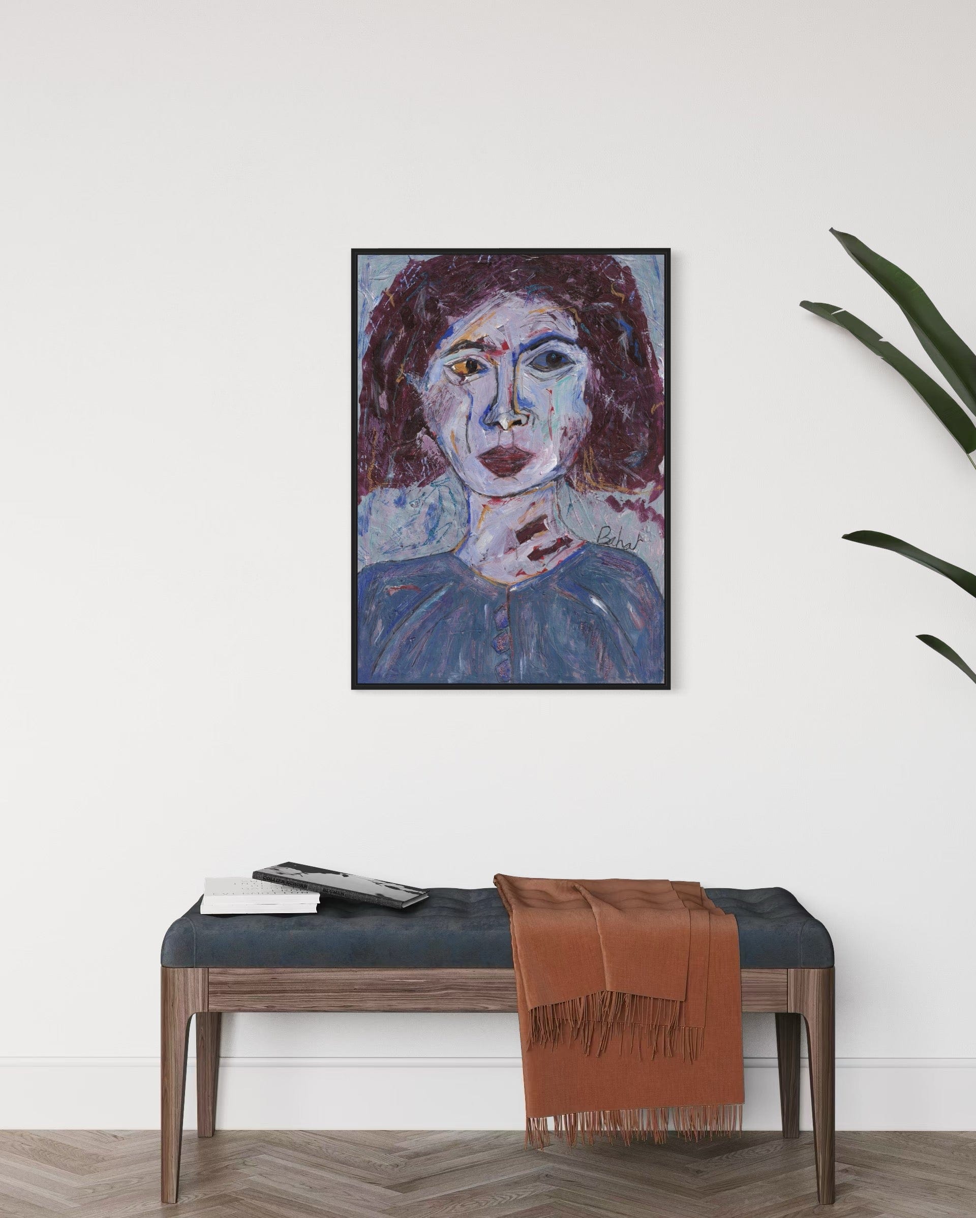 Framed abstract painting on a wall above a bench with a brown scarf.