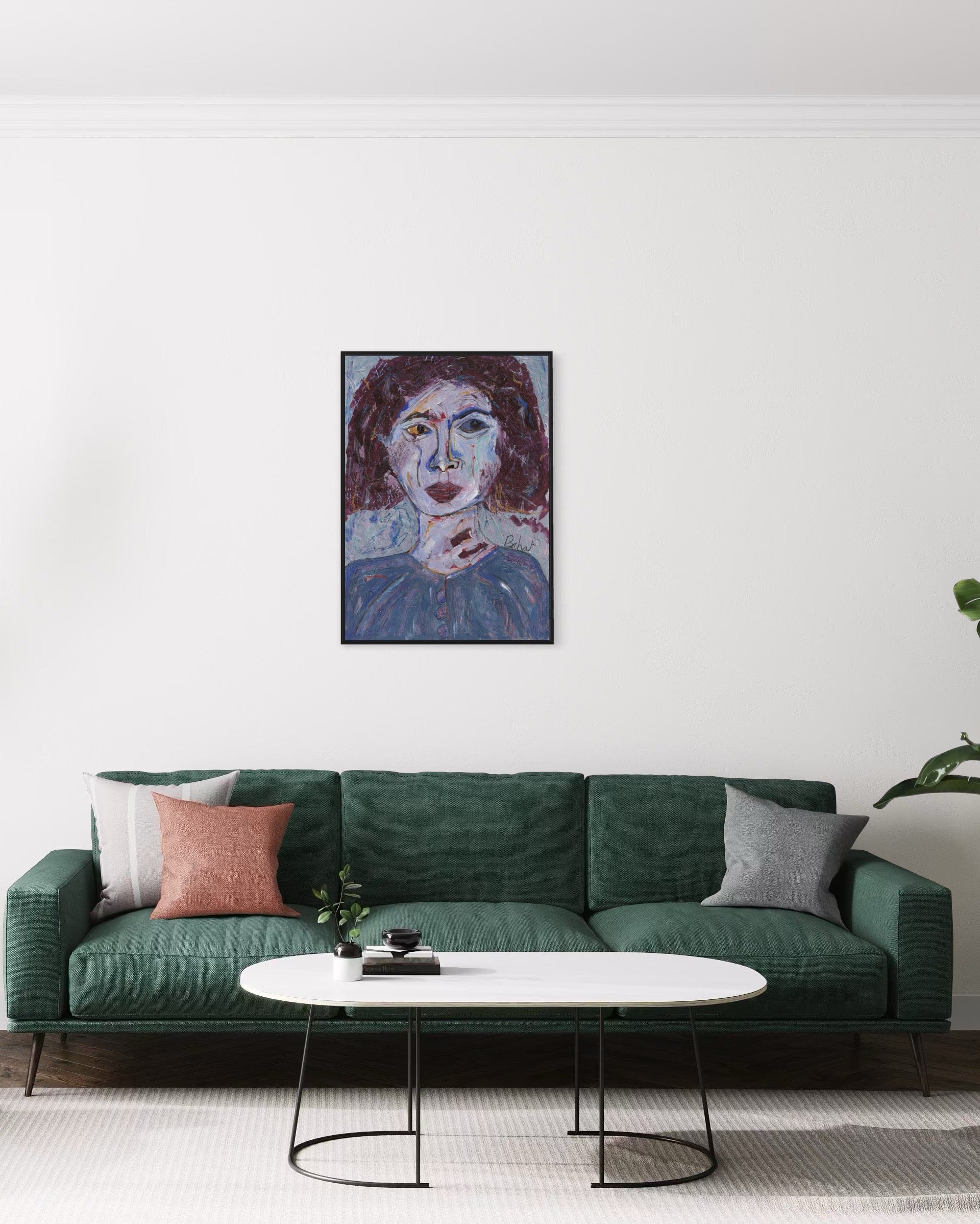 Green sofa with decorative pillows in a living room setting, featuring a portrait painting on the wall.