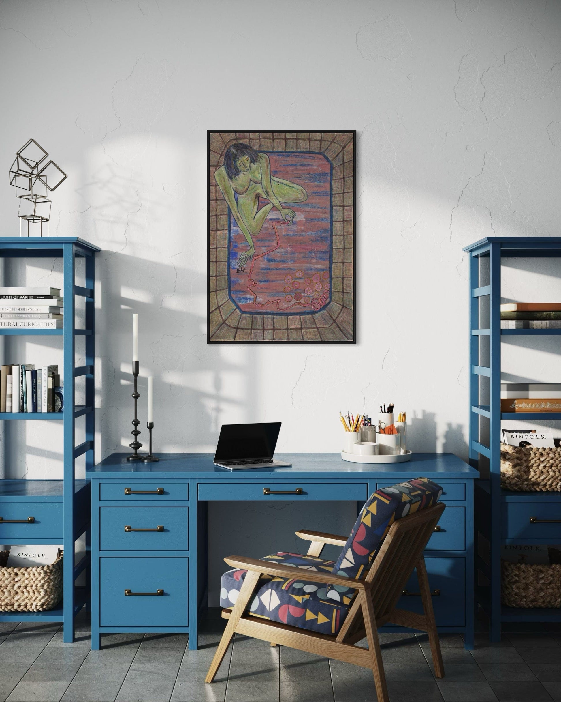 Home office with blue desk, chair, and bookshelves, featuring a framed artwork on the wall.