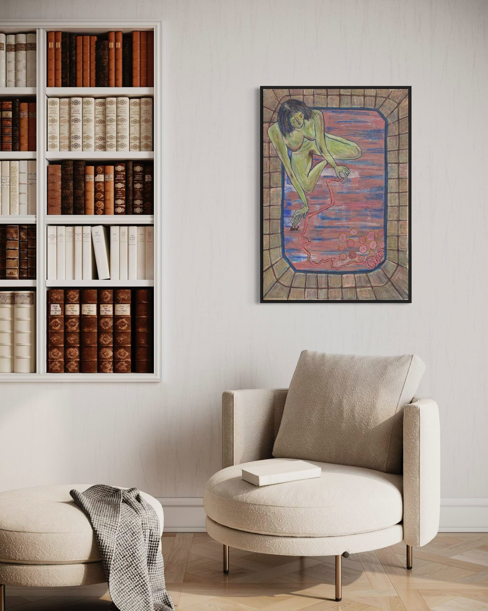 Living room with a bookshelf, armchair, and wall art.
