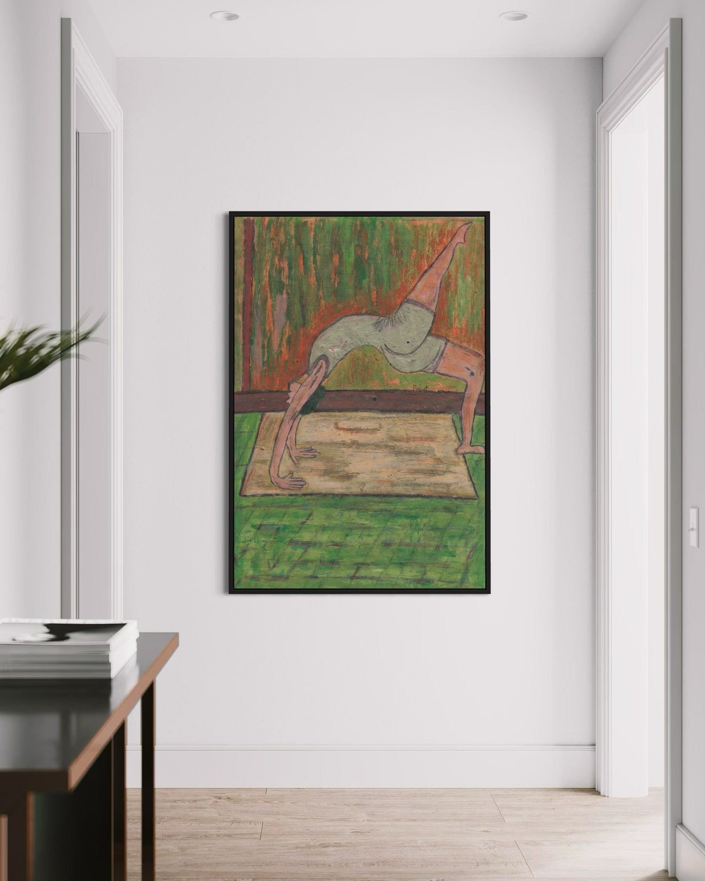 Framed artwork of a person in a yoga pose on a white wall.