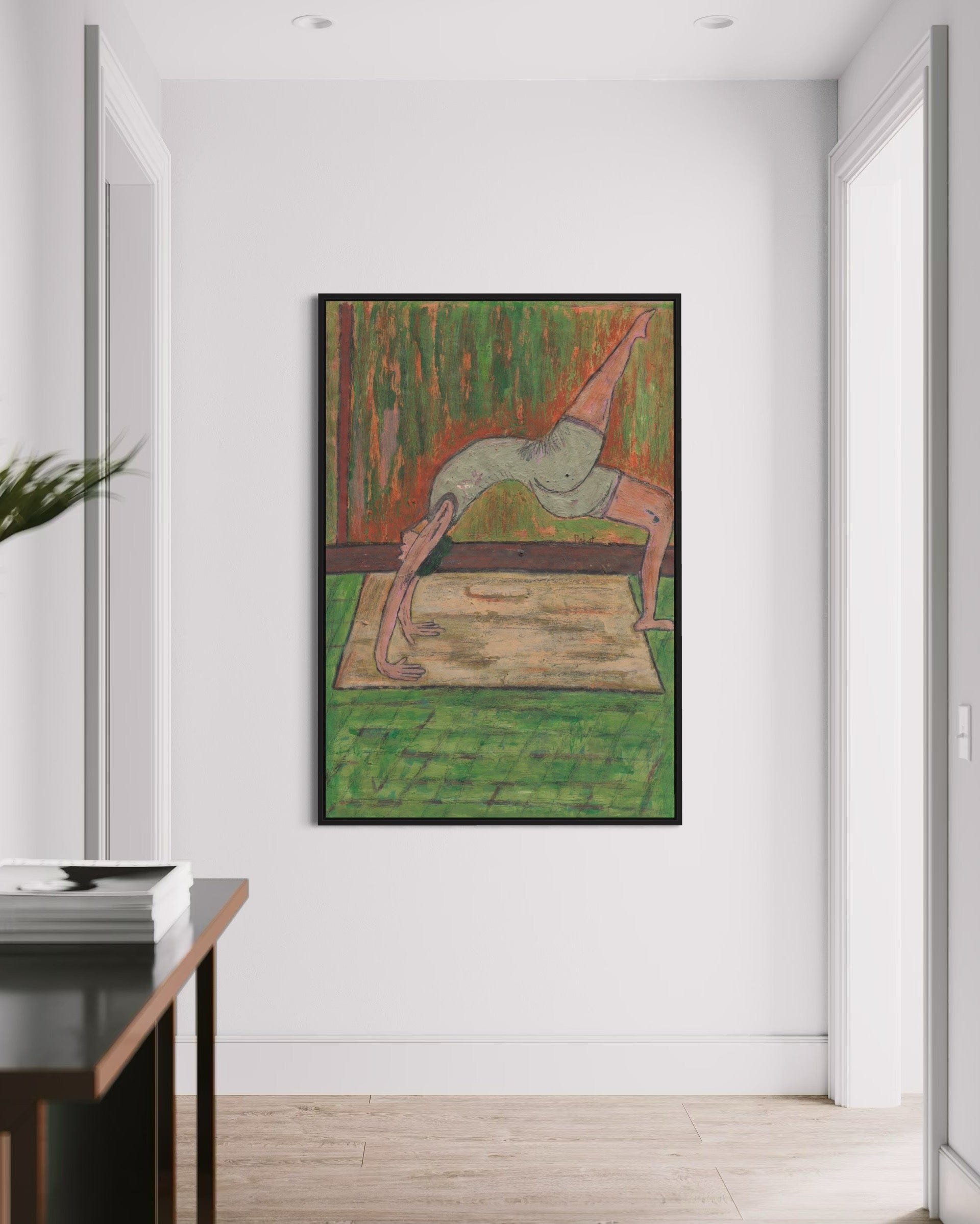 Framed artwork of a person in a yoga pose on a white wall.