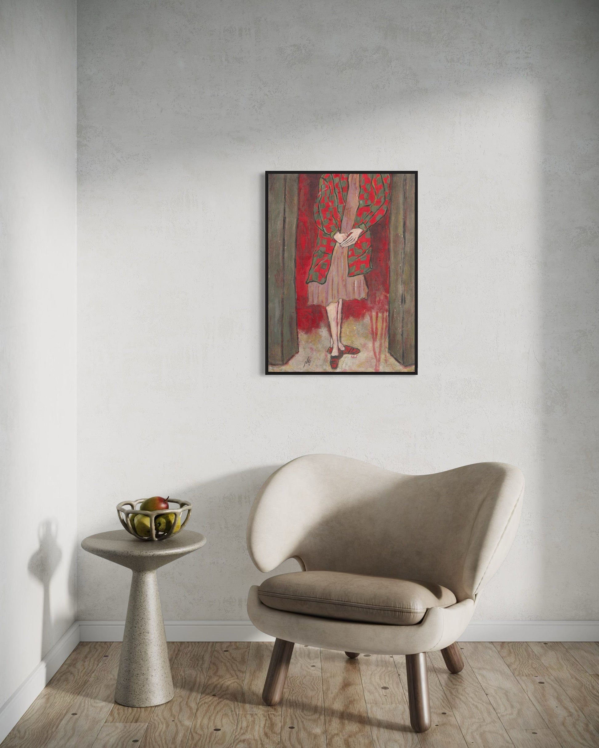 Beige armchair in a room with a wall painting and small table.