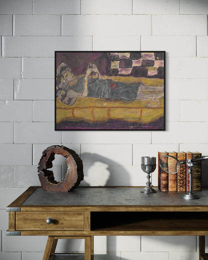 Framed artwork on a wall above a wooden table with decorative items.