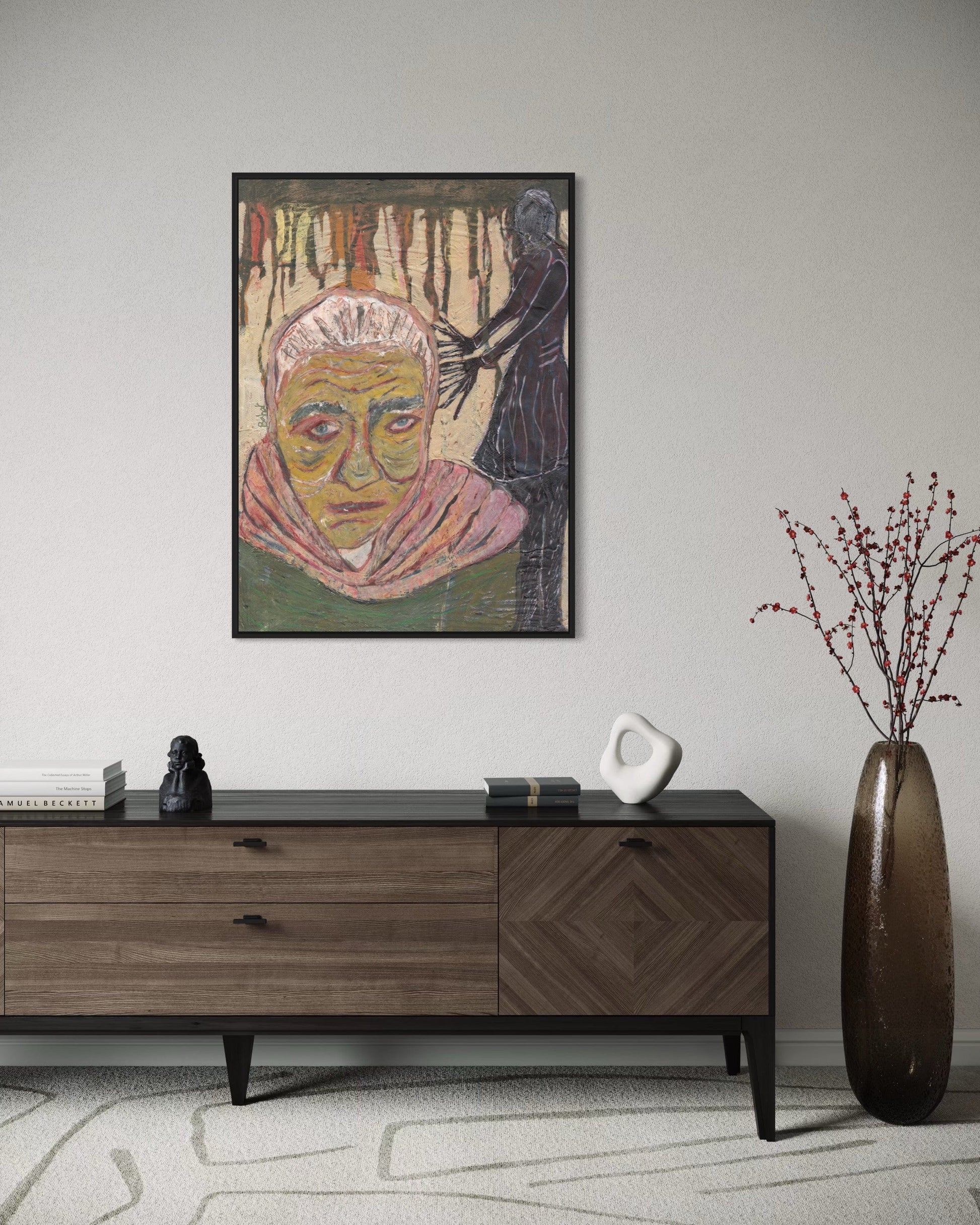 Framed artwork on a wall above a wooden sideboard with decorative items.