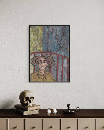 Framed artwork of a person wearing a hat on a wall above a desk with a skull and books.