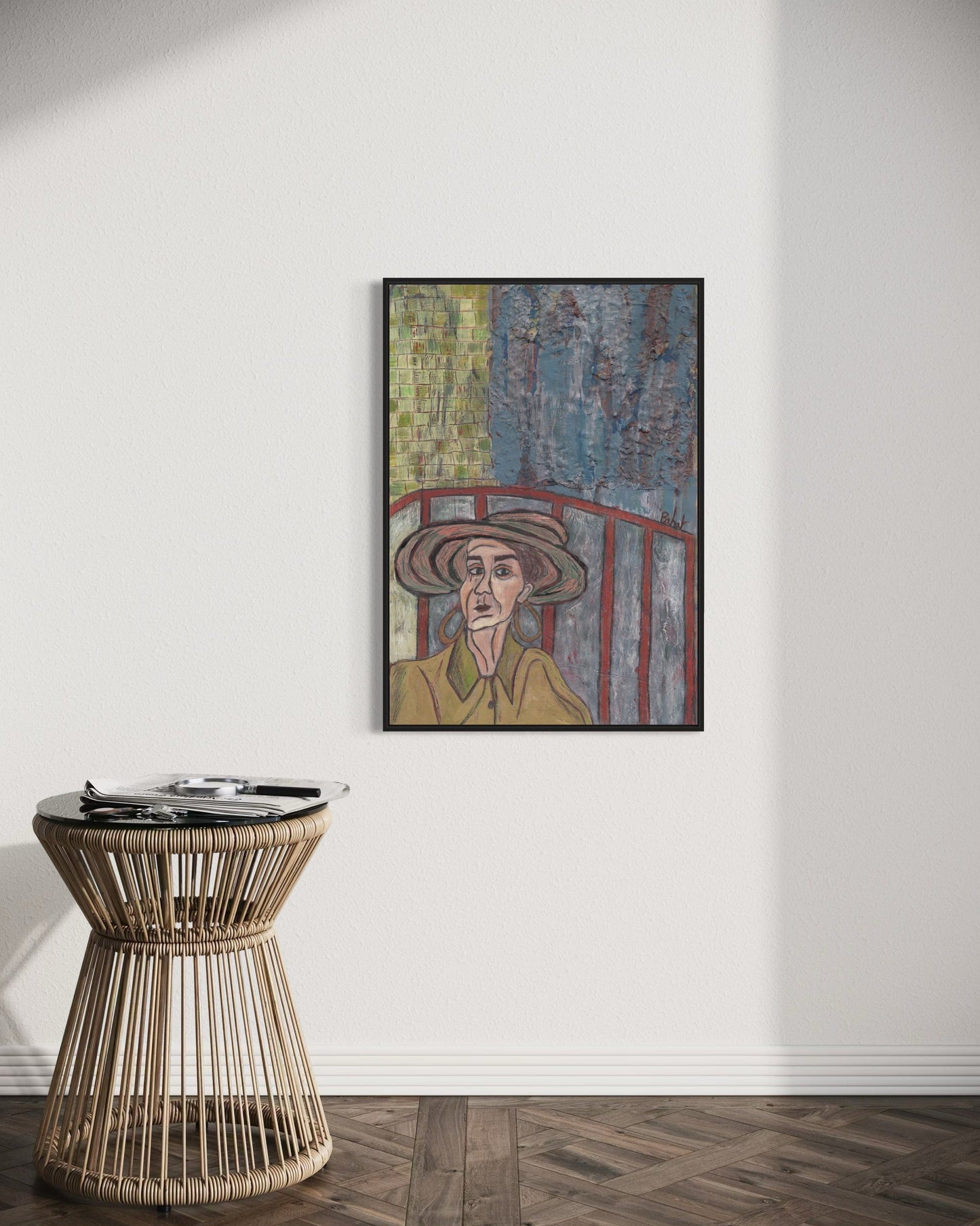 Framed artwork on a wall above a wicker side table.