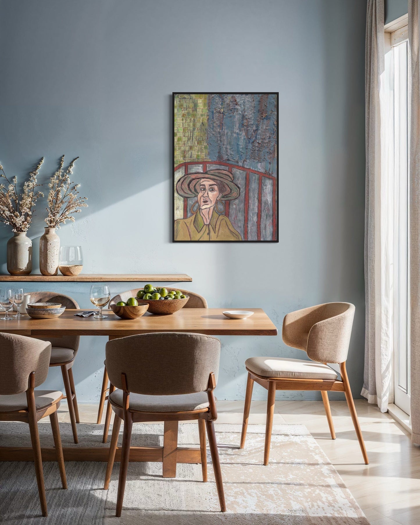 Dining room with wooden table and chairs, framed artwork on the wall, and natural light.