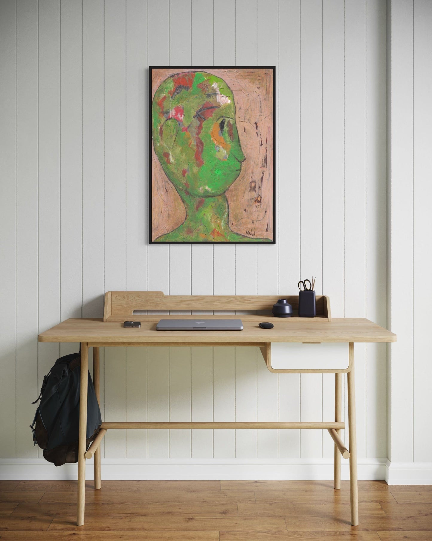 Wooden desk with a backpack and items against a white paneled wall with a colorful abstract painting.