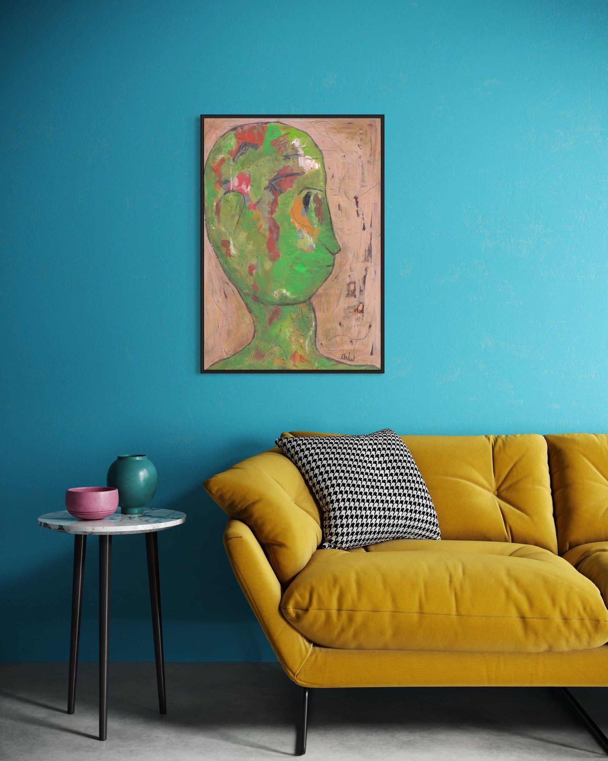 Yellow sofa with a checkered pillow against a blue wall with a framed abstract painting.
