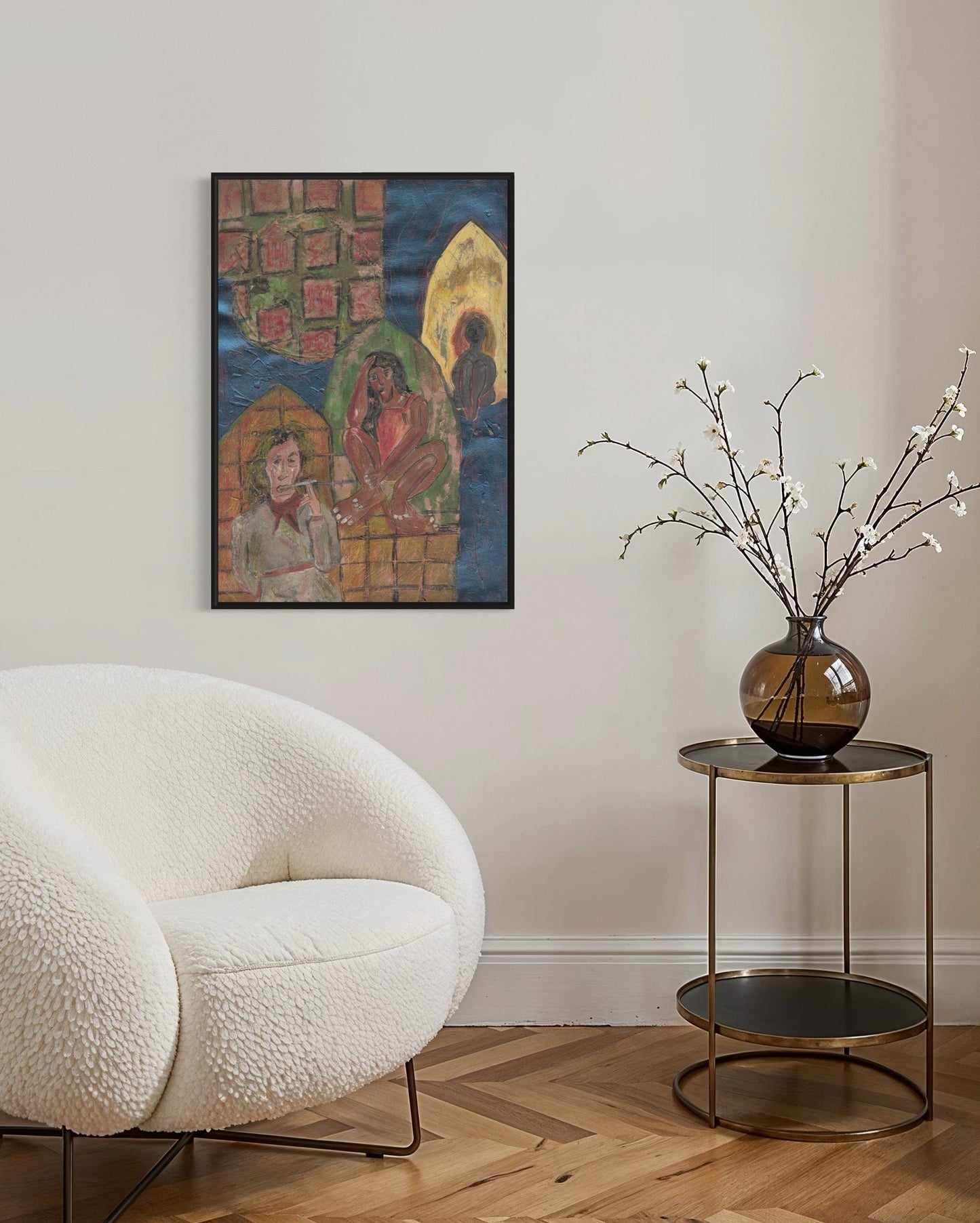 Modern living room with a white armchair, side table with a vase, and wall art.