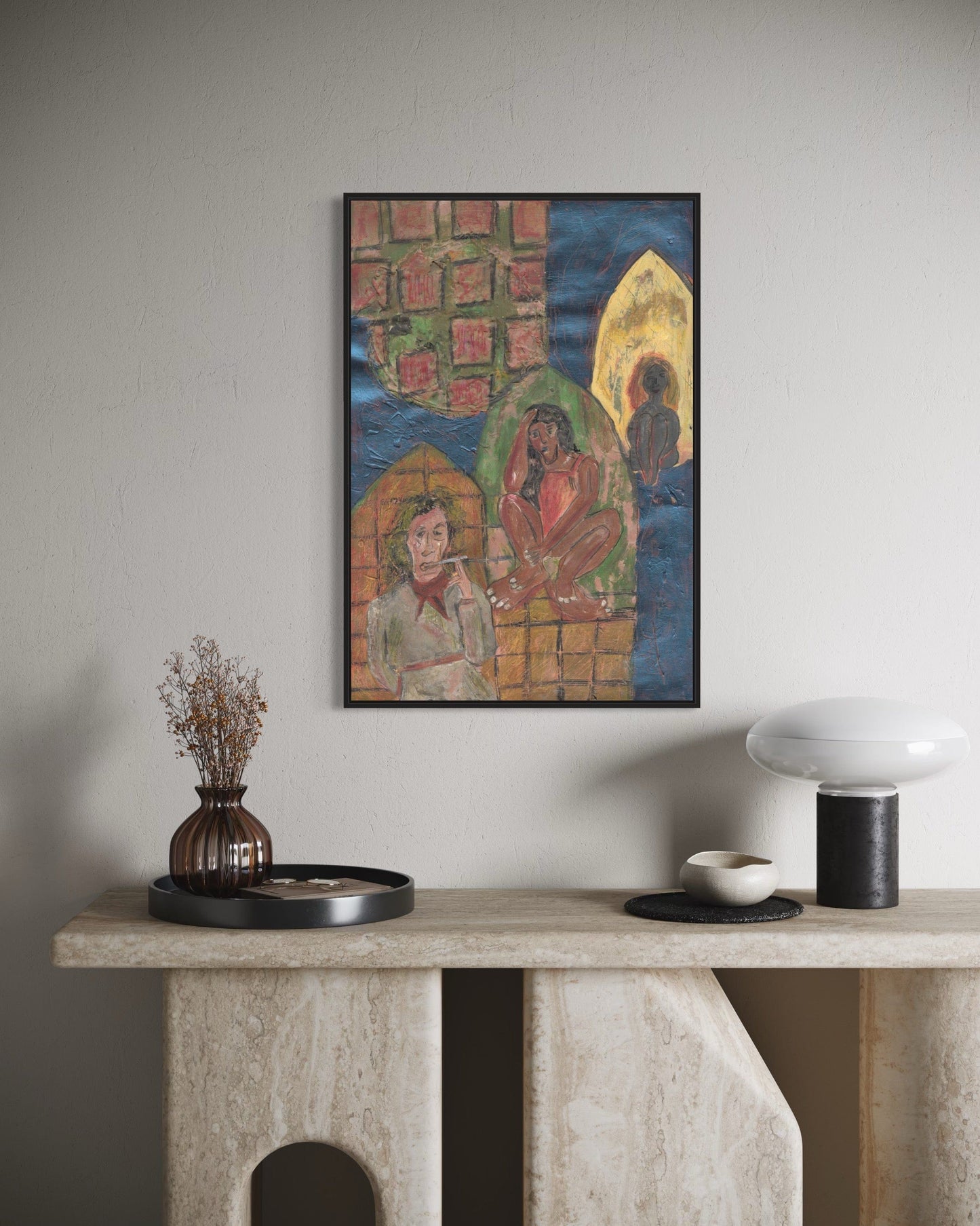 Framed artwork on a wall above a console table with decorative items.