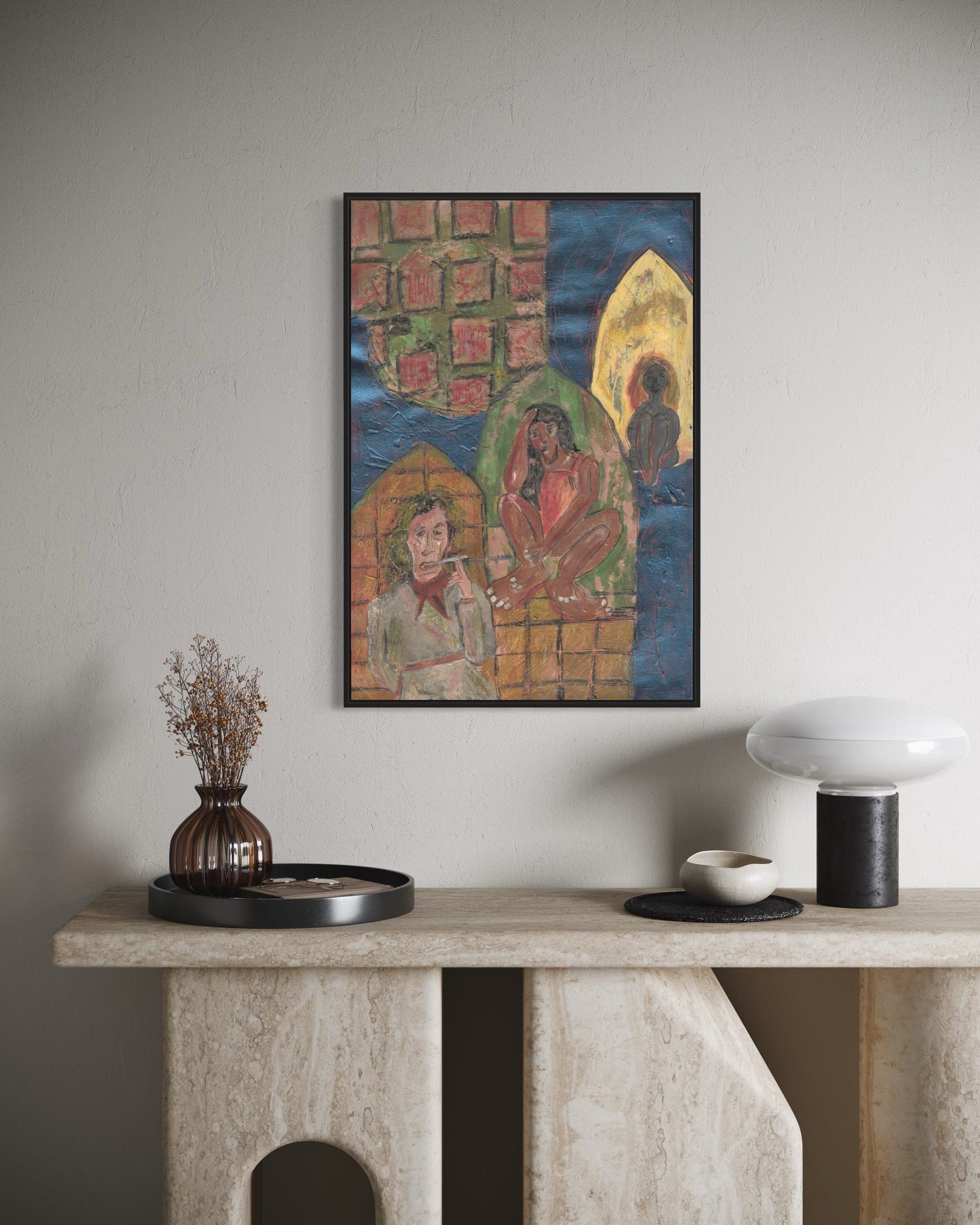 Framed artwork on a wall above a console table with decorative items.