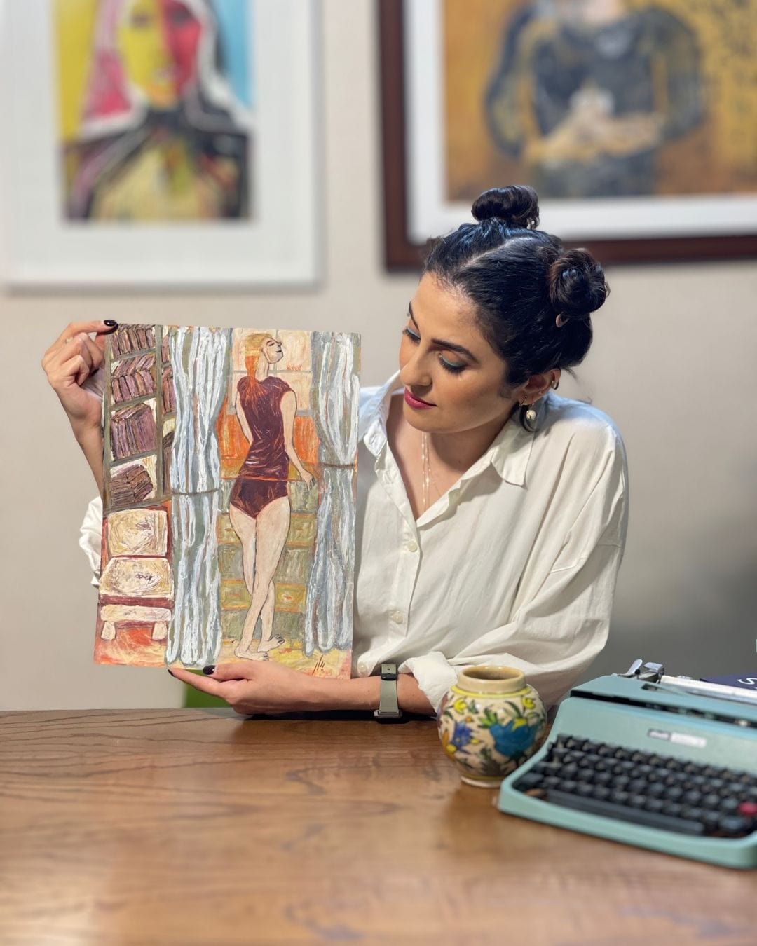 Woman holding a vintage-style magazine with a pin-up cover in an office setting.