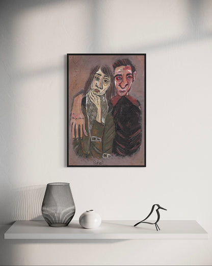 Framed artwork of two people on a white wall above a shelf with decorative items.